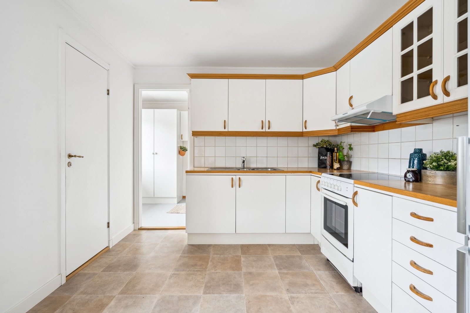 Kjøkkenet har innredning med glatte fronter og glassfronter Galleribilde