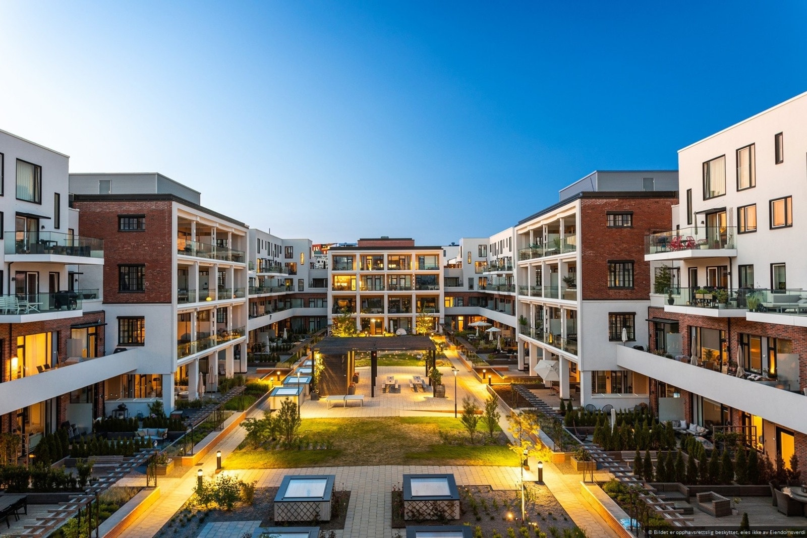 Atrium i sameiet har flere benkeplasser og grøntområder med forskjellig busker og blomster. Atriumet kun for beboere Galleribilde