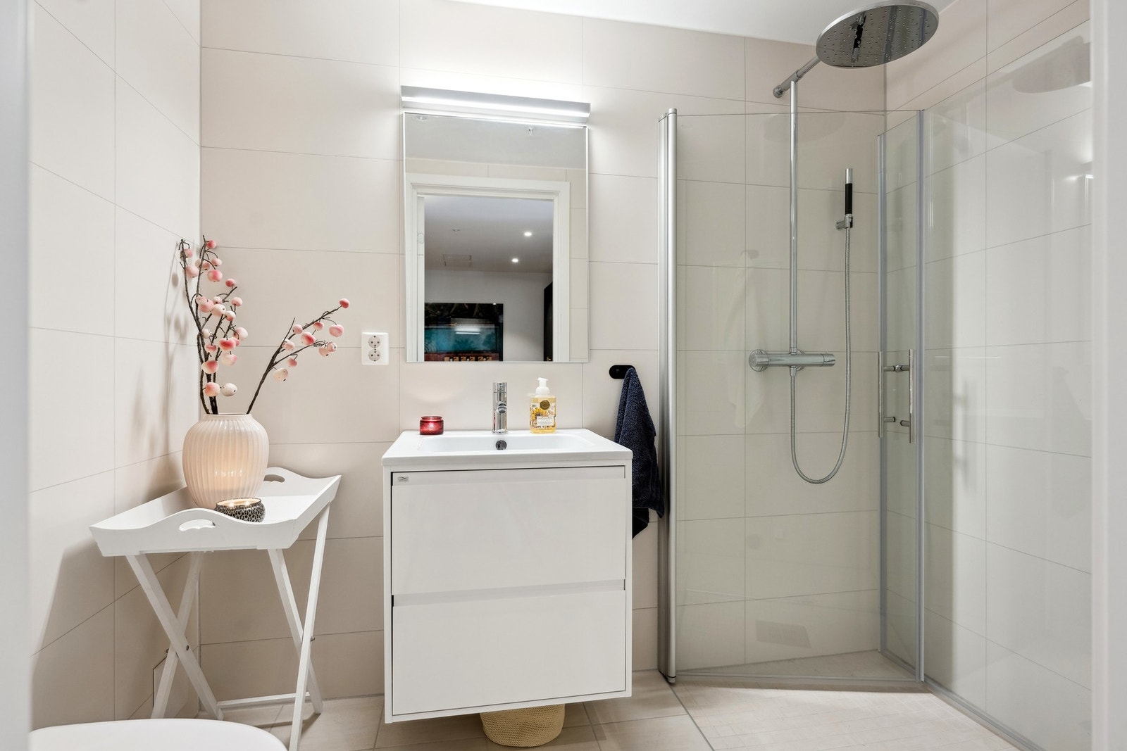 Badene har dusjnisje med innfellbare dusjvegger, vegghengt toalett og et fint servantmøblement samt downlights i taket Galleribilde