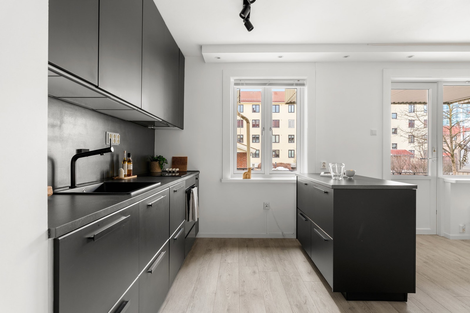 Praktisk innredet med rikelig med skap- og benkeplass. Innredningen har mørke, glatte fronter og benkeplate av laminat med nedfelt oppvaskkum. Galleribilde