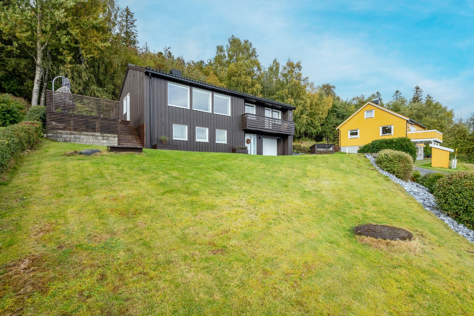 På forsiden av boligen har man skrående tomt som er beplantet med plen. Galleribilde