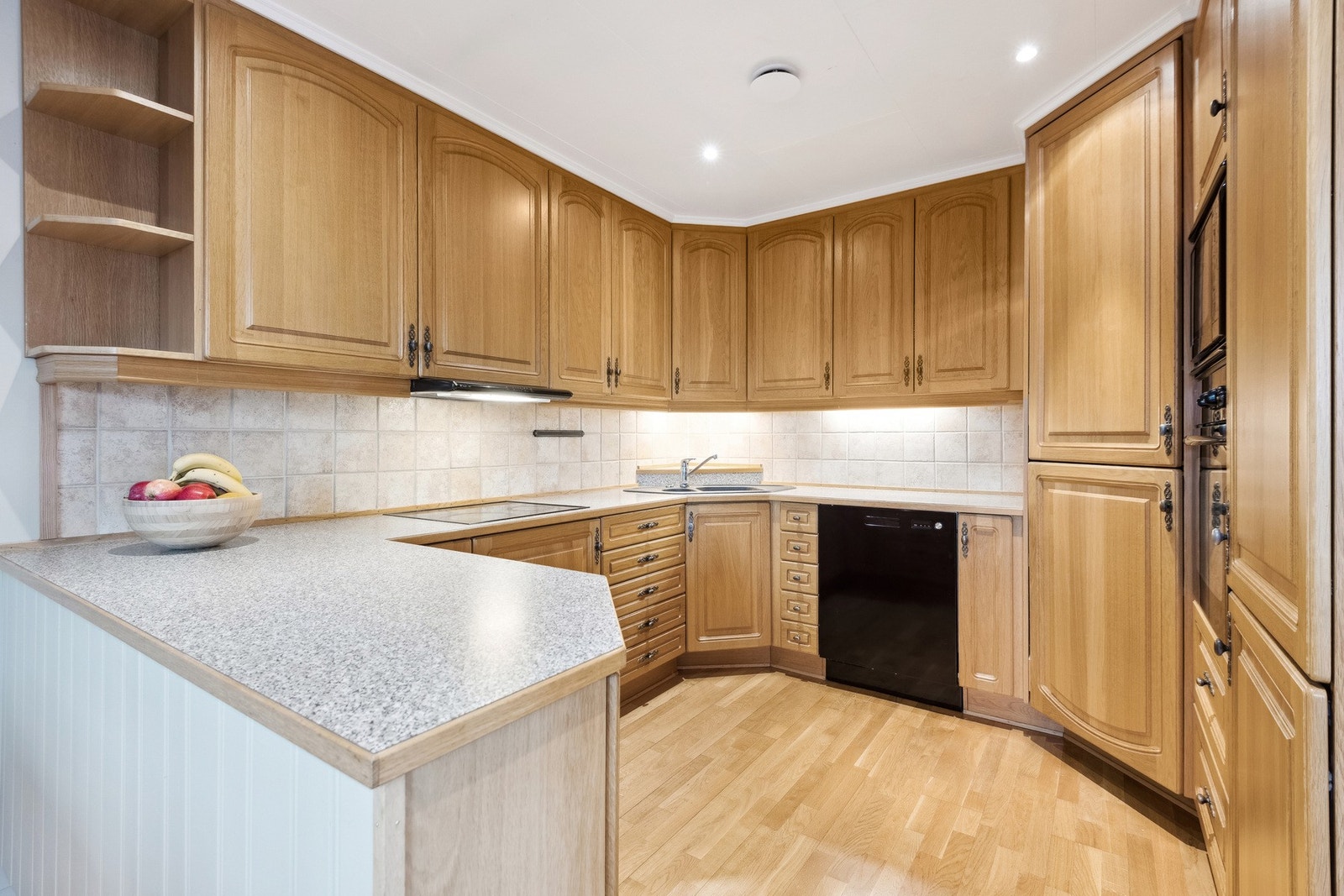 Stort og innbydende kjøkken med integrerte hvitevarer. Galleribilde