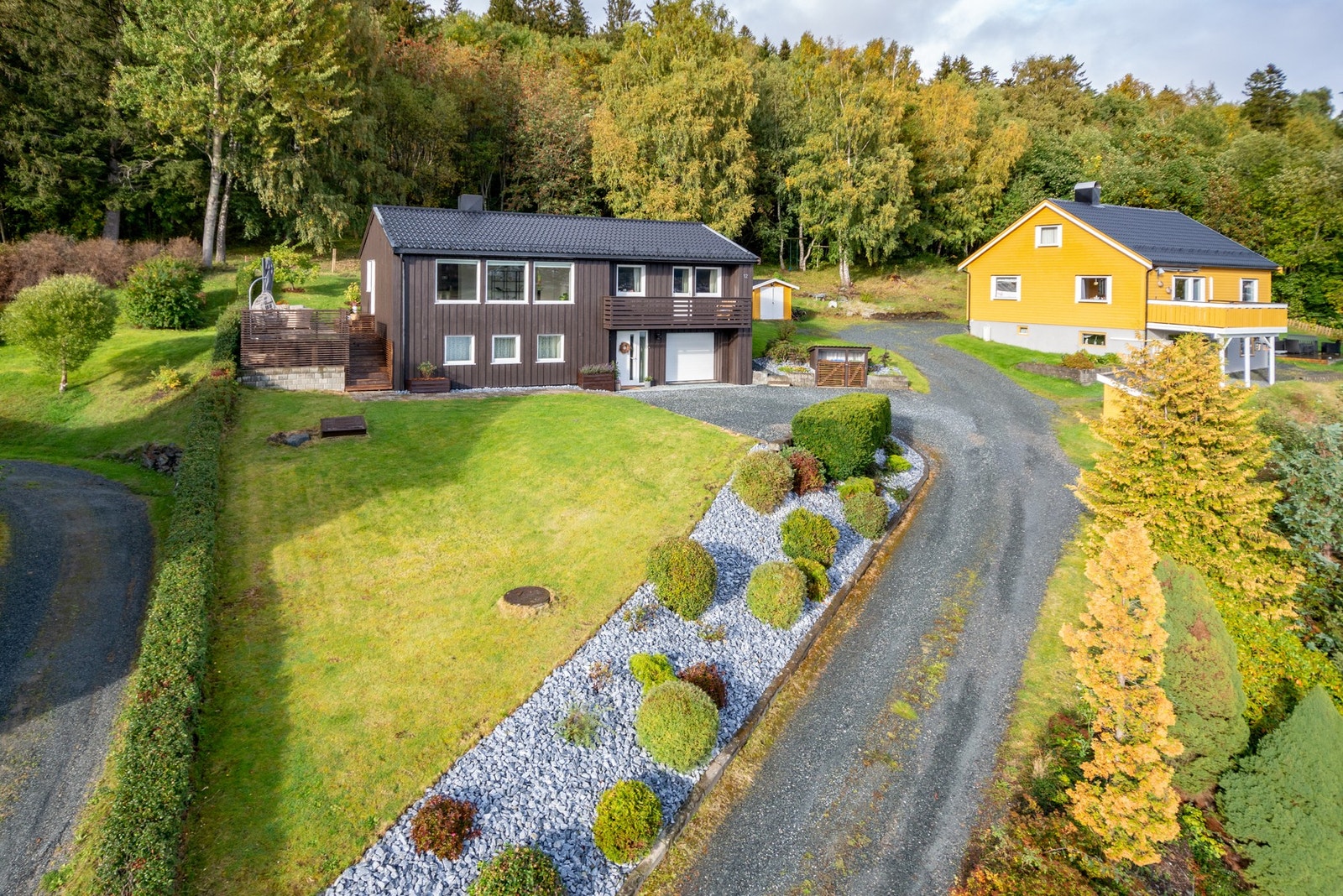 Boligens eiendom er pent opparbeidet med plen, bed og prydbusker. Galleribilde