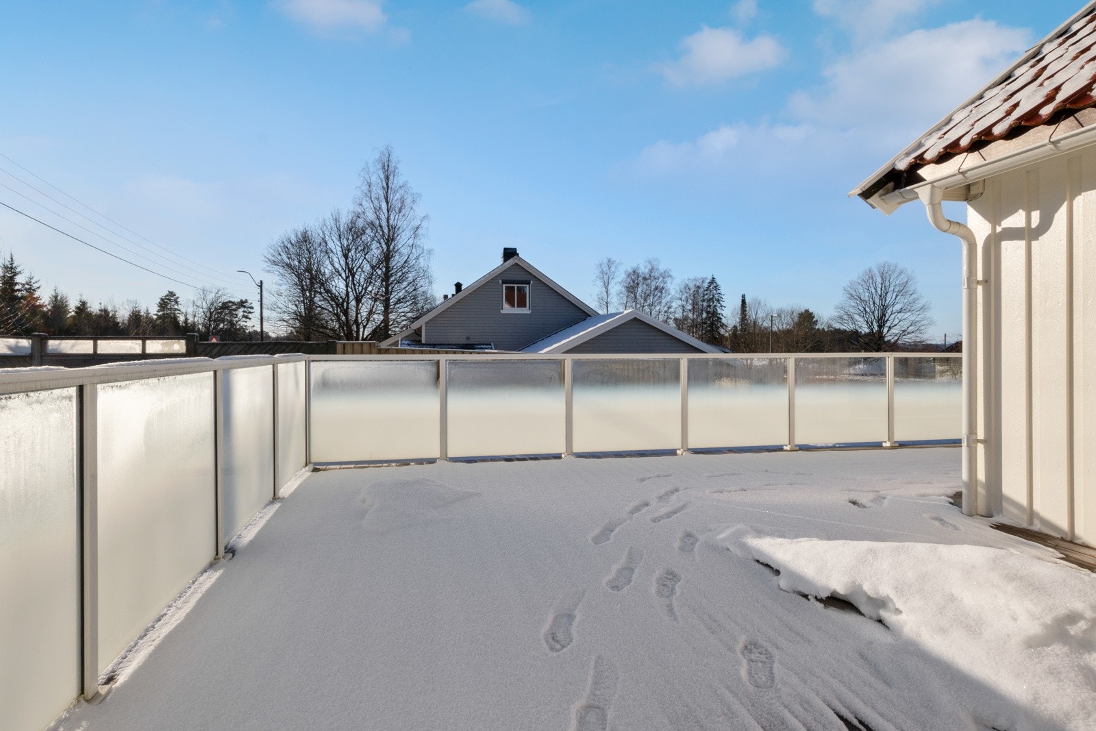 Fra stuen og soverommet i første etasje er det utgang til en stor terrasse, med stilrent glassrekkverk og trapp ned til den flotte hagen. Galleribilde