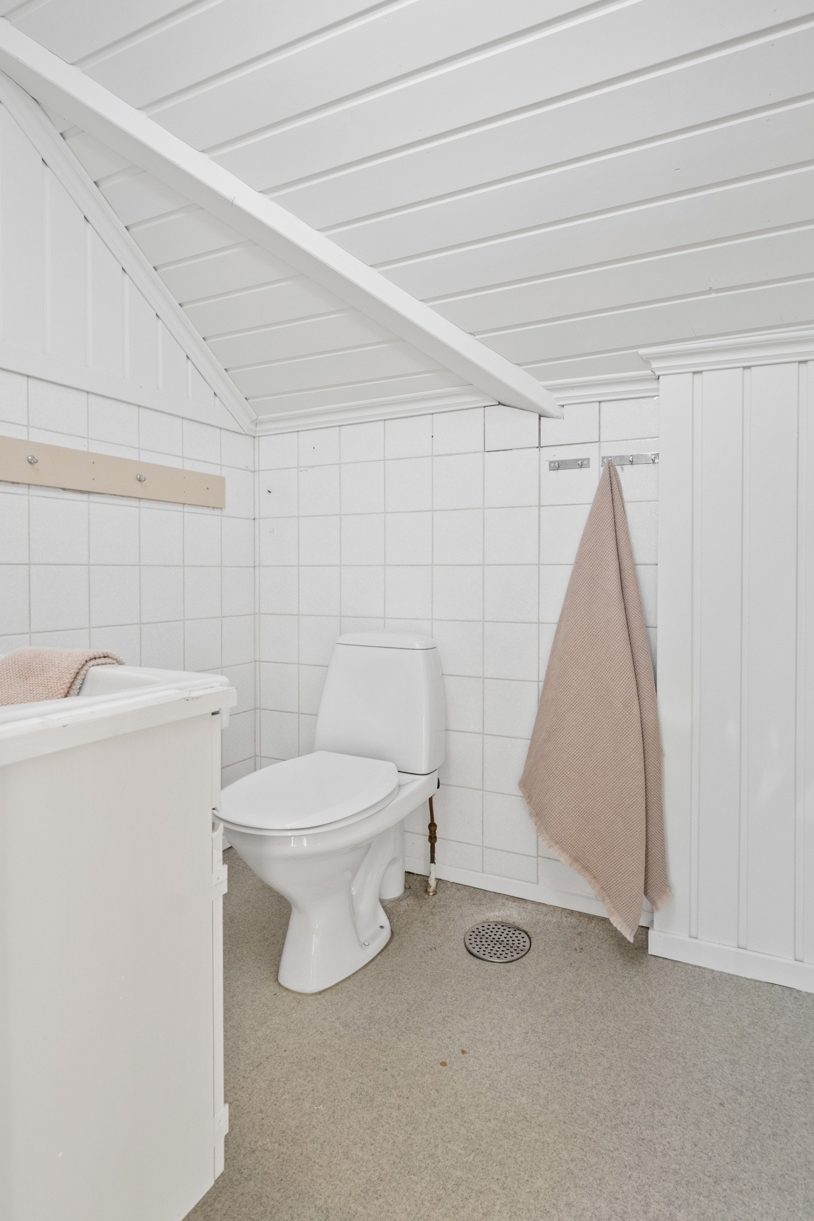 Wc-rommet er innredet med toalett, gulvbelegg og et hvitt servantskap. Galleribilde