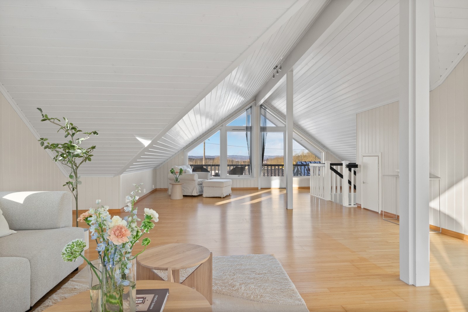 Lyset strømmer inn via store vinduer, og stuen har utgang til en balkong med fin utsikt over nærområdet. Galleribilde