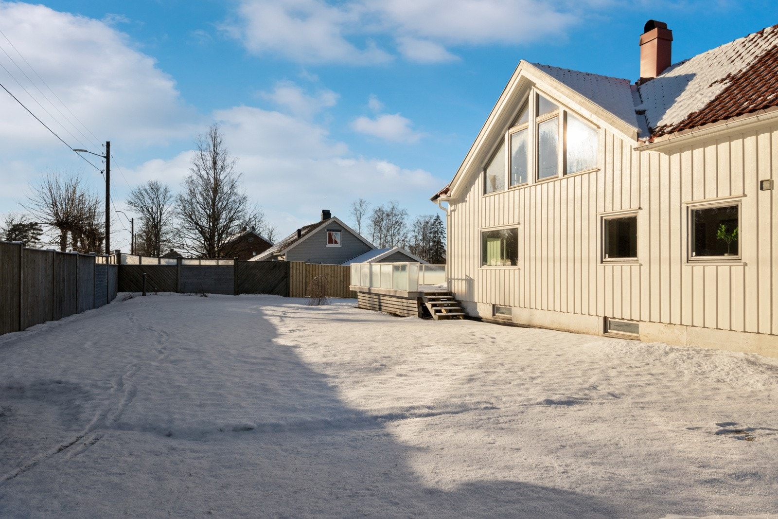 Selve tomten er på over 1,4 mål, pent opparbeidet med gressplen, trær, busker, stakittgjerde mot veien og skjermvegger i bakkant. Galleribilde