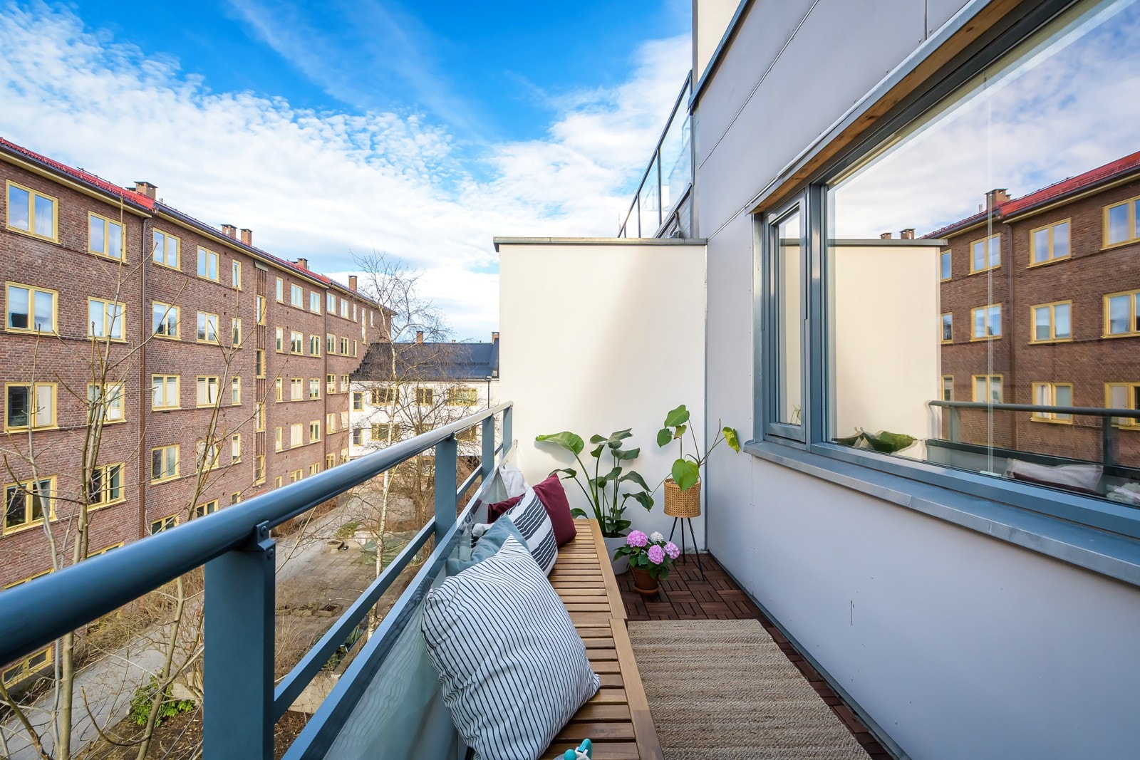 Balkongen har støpt dekke belagt med nye terrasseheller i 2025 og rekkverk av metall med glassfelt. Galleribilde
