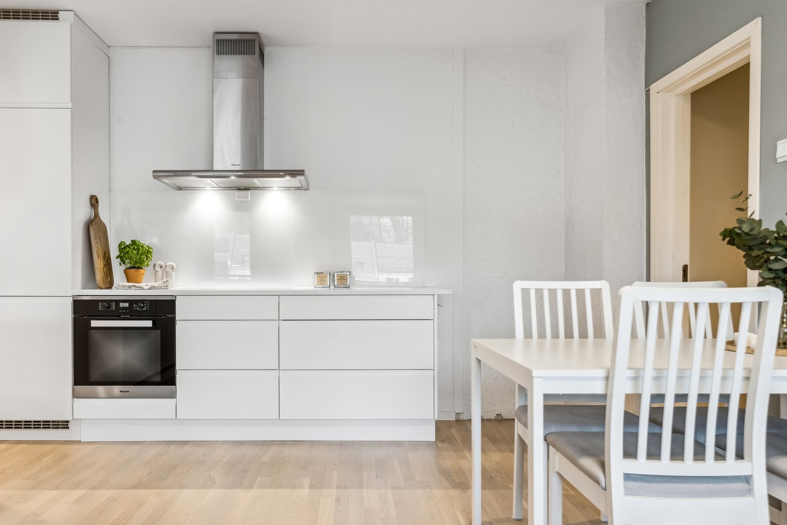 Kjøkkeninnredning med slette fronter, rikelig skap- og benkeplass samt benkeplater i stein. Galleribilde