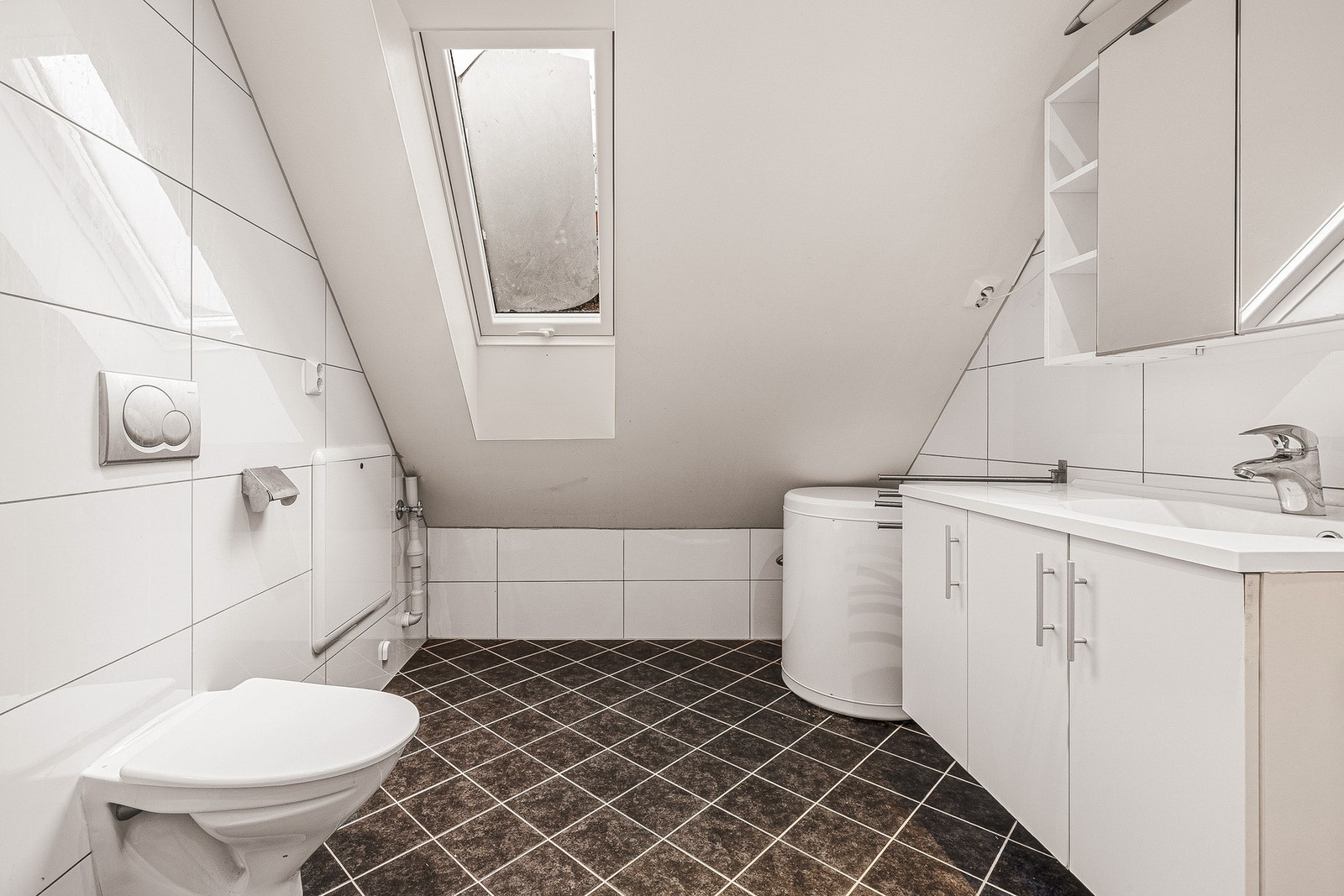 Badet er innredet med keramiske fliser på vegger, elektriske varmekabler og innfelte spotlights i tak Galleribilde