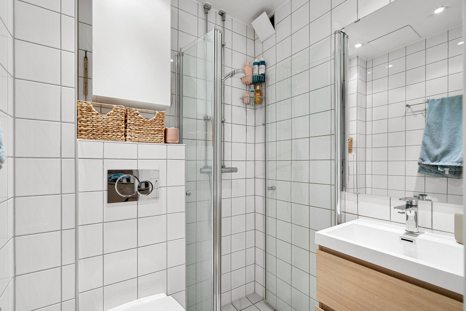 Vegghengt toalett, servant og speilskap. Dusjhørne med innfellbare dører. Galleribilde