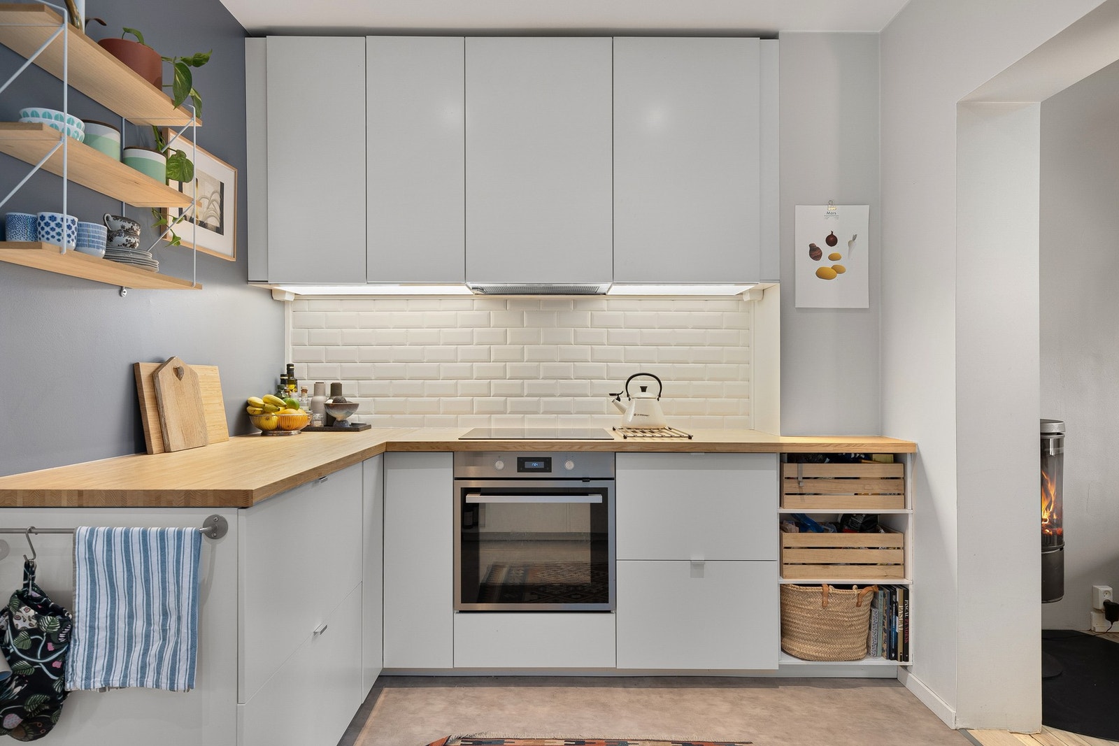 IKEA-kjøkken med heltre benkeplate og belysning under kjøkkenskap. Galleribilde