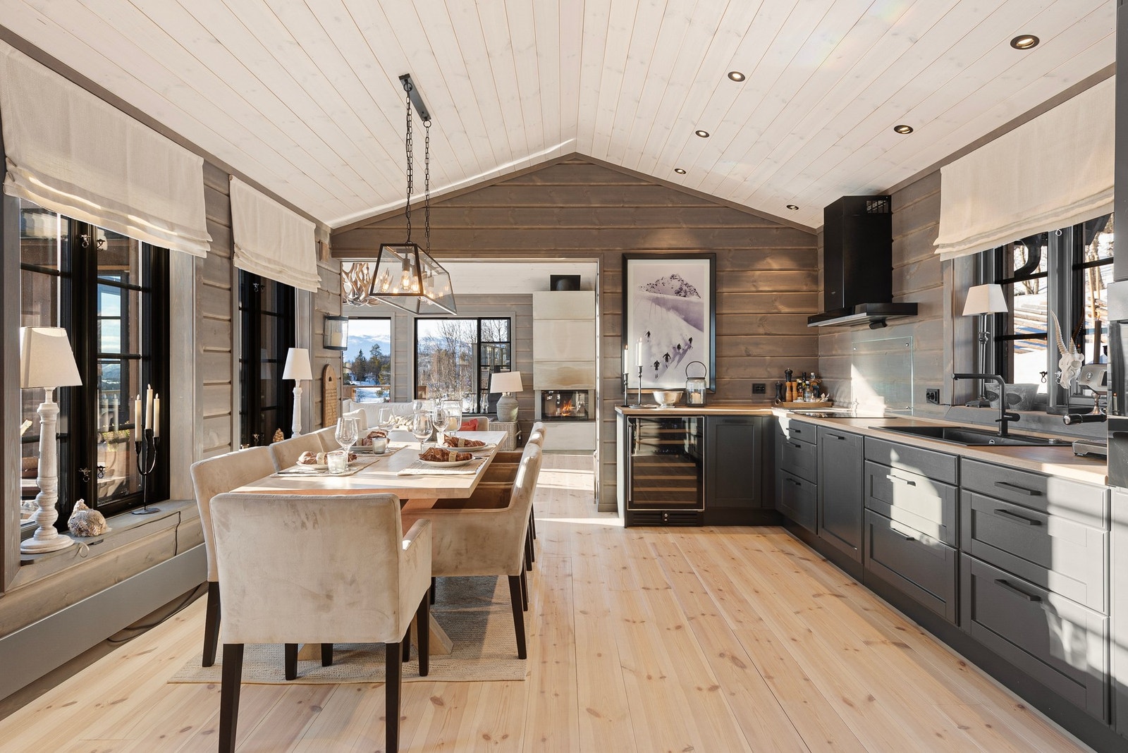 Delvis åpen løsning mot stue gjør kjøkkenet pent tilbaketrukket, samtidig som rommet oppleves sosialt og hyggelig Galleribilde