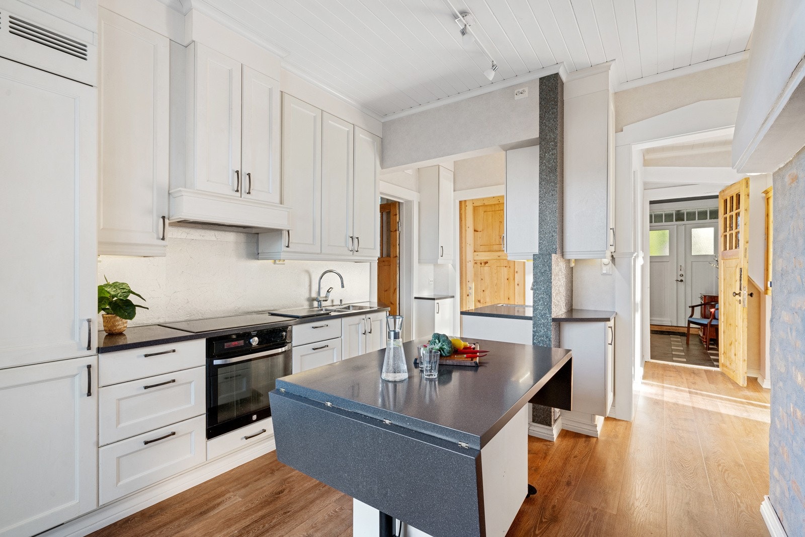 Bordet i midten er spesialtilpasset kan heves og senkes. Det kan brukes til både spisebord og/eller som ekstra benkeplass. Galleribilde