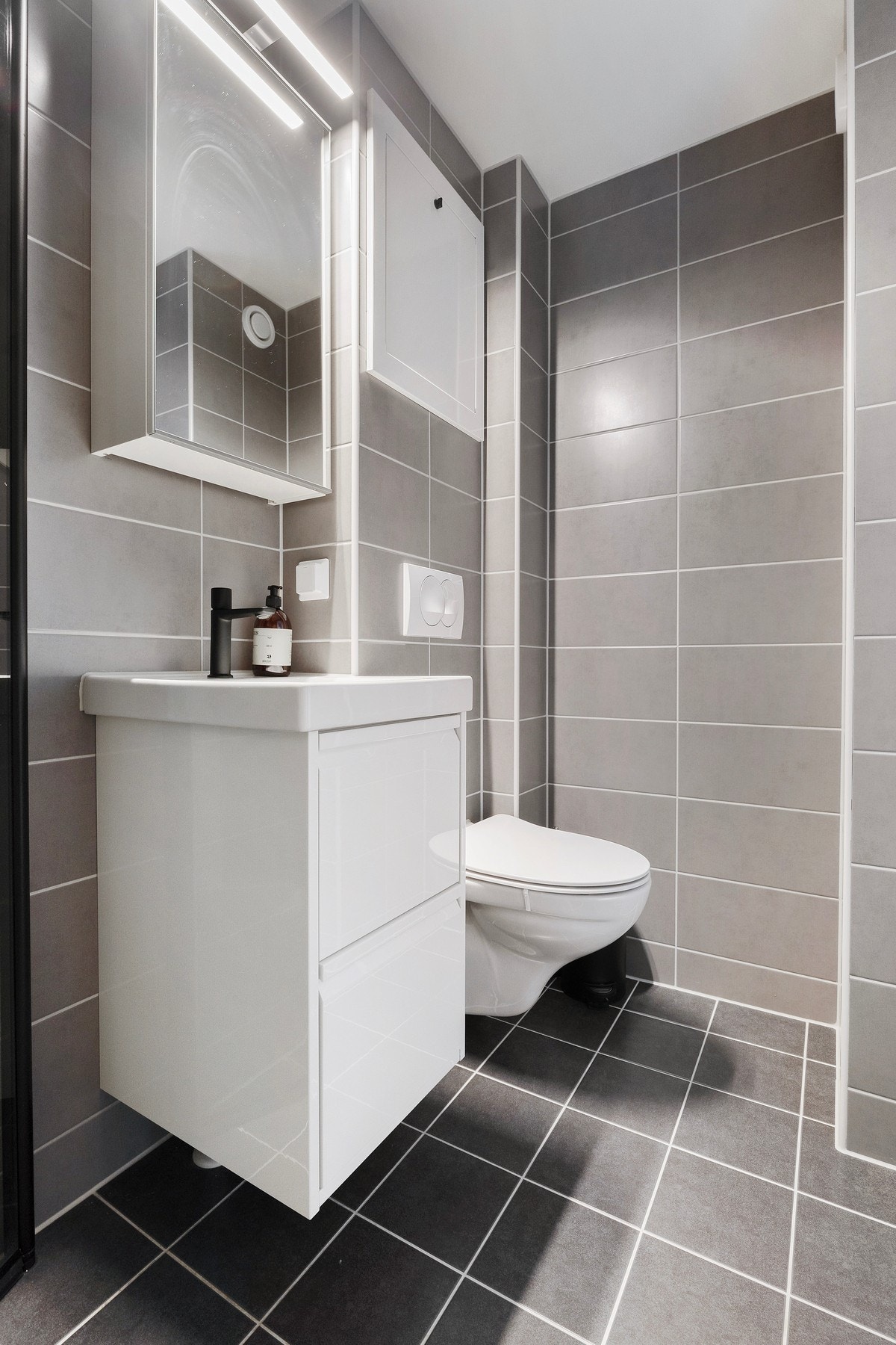 Et pent flislagt bad med gode lyskilder og et stilfult utseende. Galleribilde