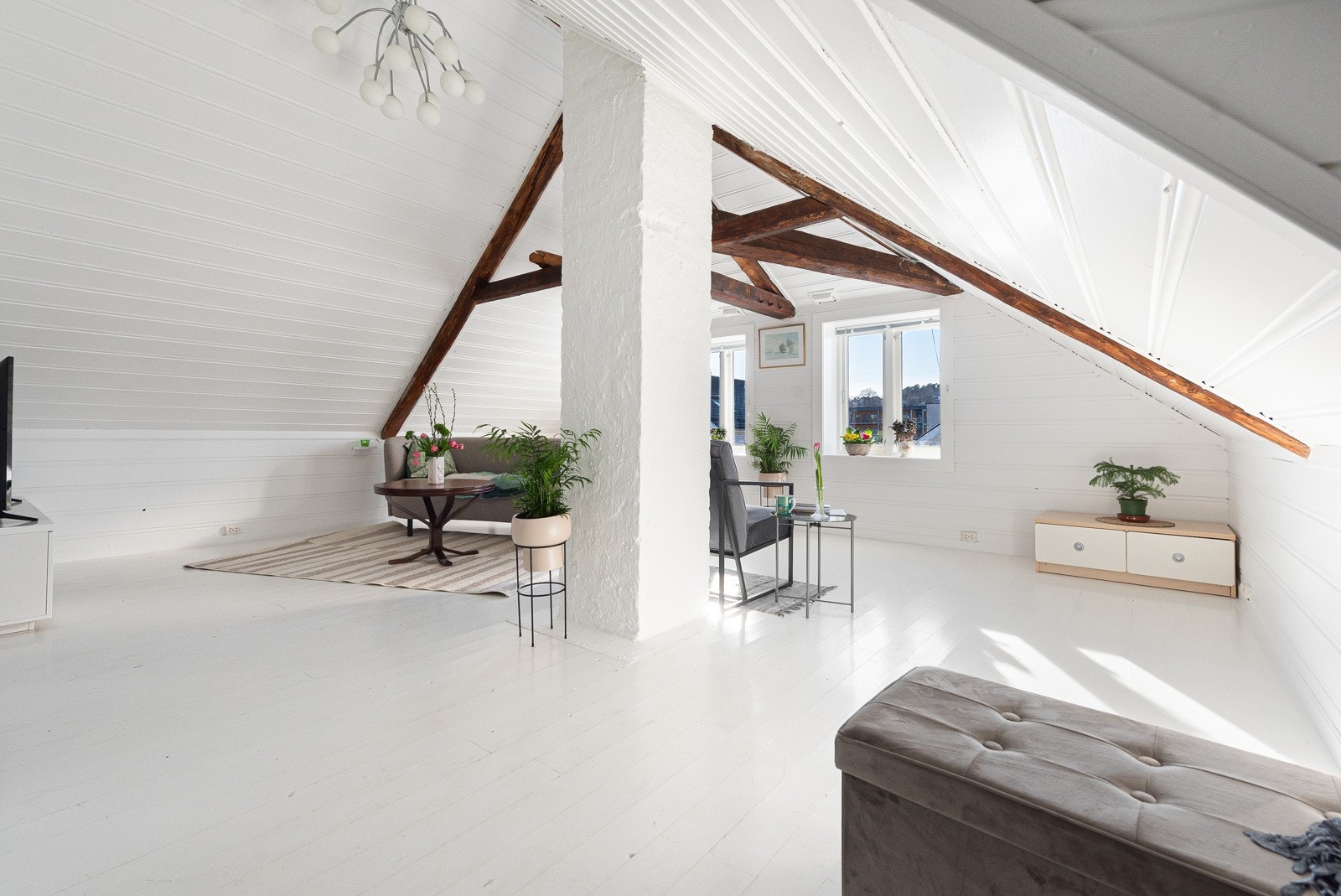 Det er god plass til flere sittegrupper i stuen. Store vinduer gir godt med naturlig lys. Galleribilde