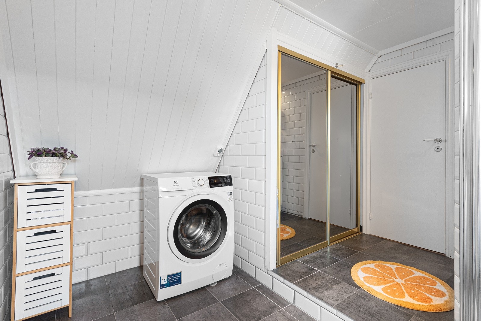 Videre har rommet opplegg for vaskemaskin og en skyvedør med speil for oppbevaring.Her er det også plass til en tørketrommel. Galleribilde