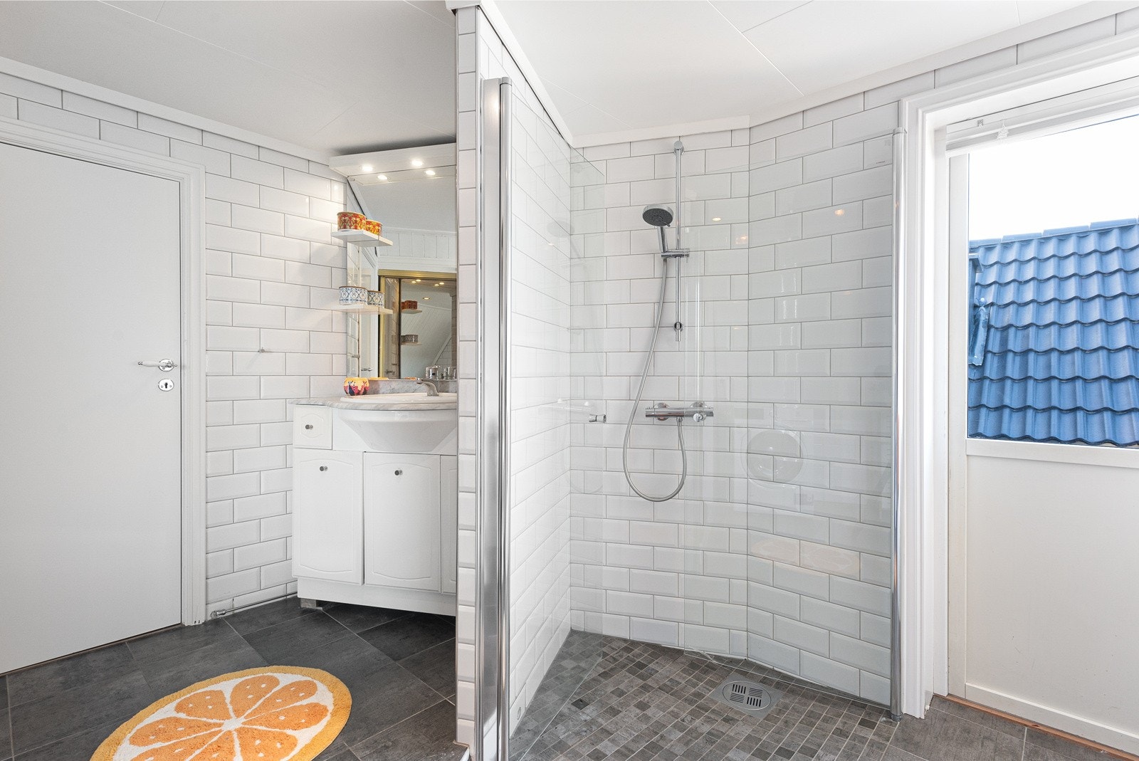 Badet har også et dusjhjørne. Veggene og gulver på badet har fliser og det er elektriske varmekabler i gulvet. Badet har naturlig ventilering og utgang til balkong. Galleribilde