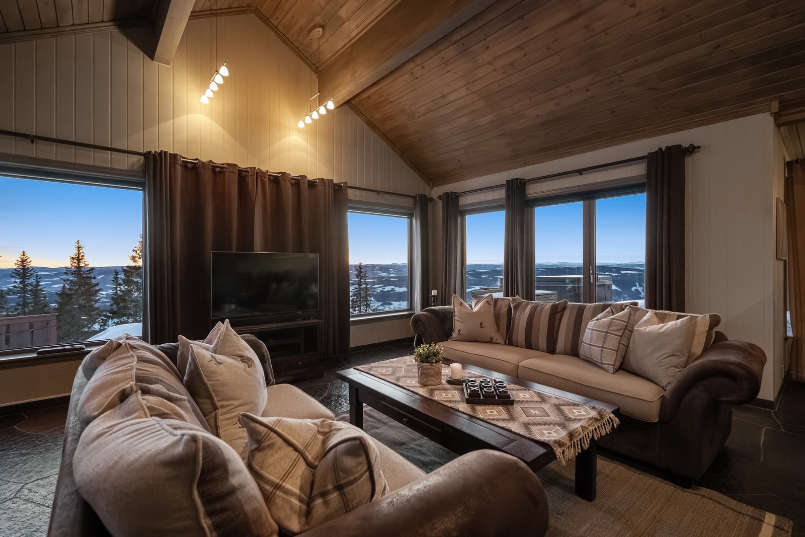 Hytta har en svært lun og koselig stue. Lysmalte panelvegger og skråhimling med panel gir en lun og koselig atmosfære. Galleribilde