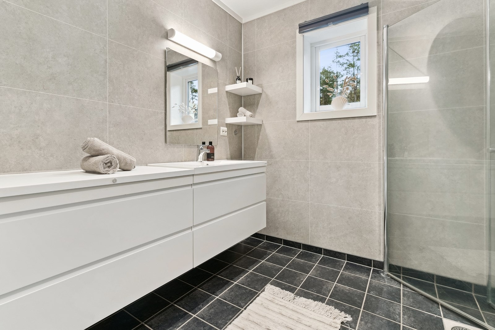 Bustaden har to bad - eitt i kvar etasje. I hovedetasjen er badet utstyrt med dobbel baderomsinnreiing, som er mogleg å nytte som stellebord samt at det gjev ekstra lagringsplass. Galleribilde