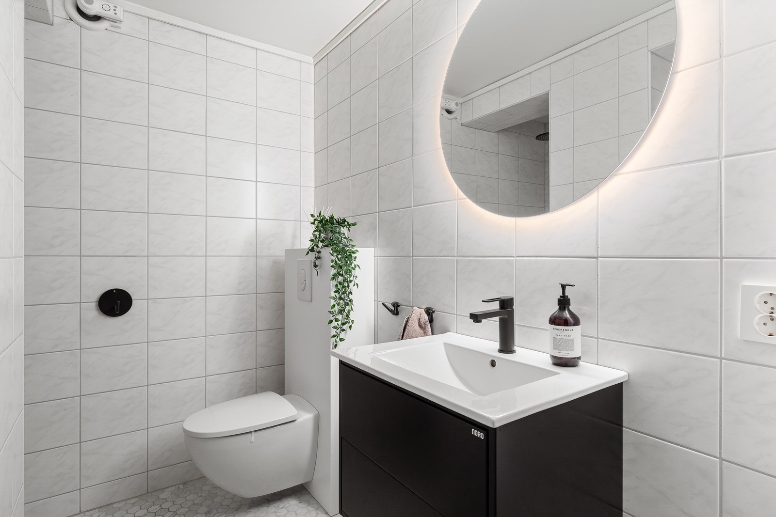 Baderom med fliser på golv og veggar, med varmekbabler i golv. Galleribilde