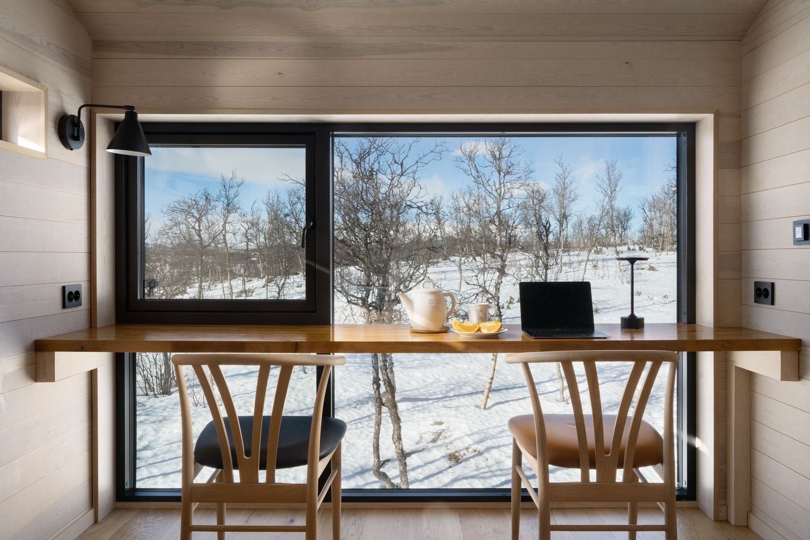 Hytten har store vinduer og gjennomlys i begge etasjer Galleribilde