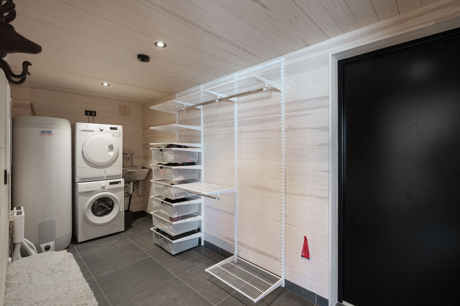 Inngangspartiet, vaskerom og gang er belagt med mørke store fliser. Galleribilde