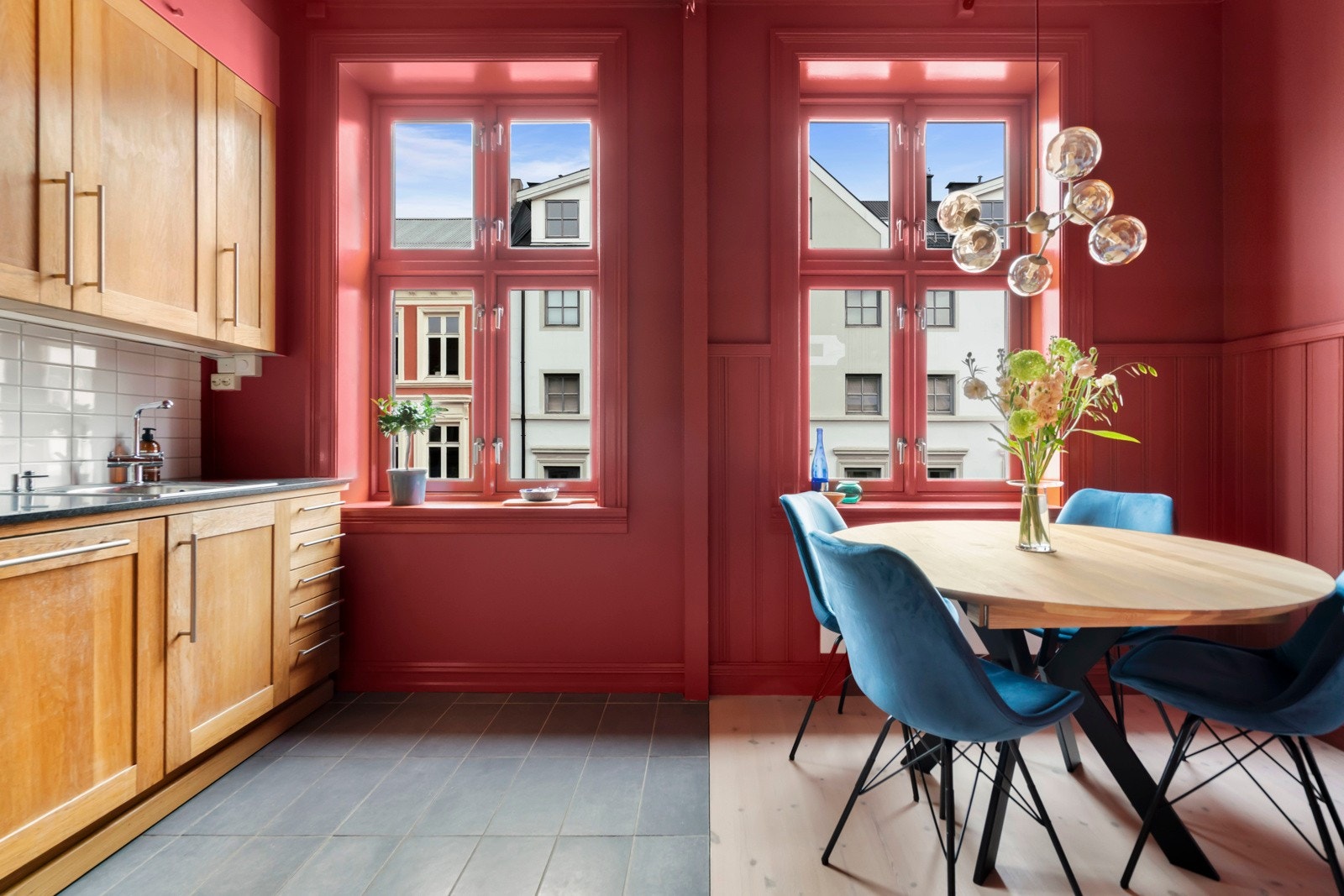 Gulvet er praktisk delt, med fliser under kjøkkendelen og lyst tregulv i spiseområdet. Galleribilde