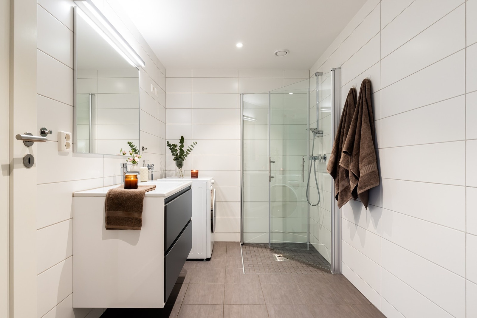 Pent, flislagt bad med vannbåren gulvvarme. Badet er utstyrt med brede skuffer i baderomsinnredning, heldekkende servant og stort speil med belysning over. Ytterligere belysning med spotter i tak. Galleribilde