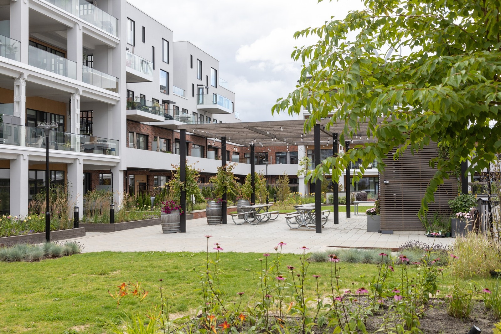 Her er det pergola og sitteplasser. Ikke lange veien fra egen leilighet og ned på gresset om det skulle være ønskelig en varm sommerdag. Galleribilde