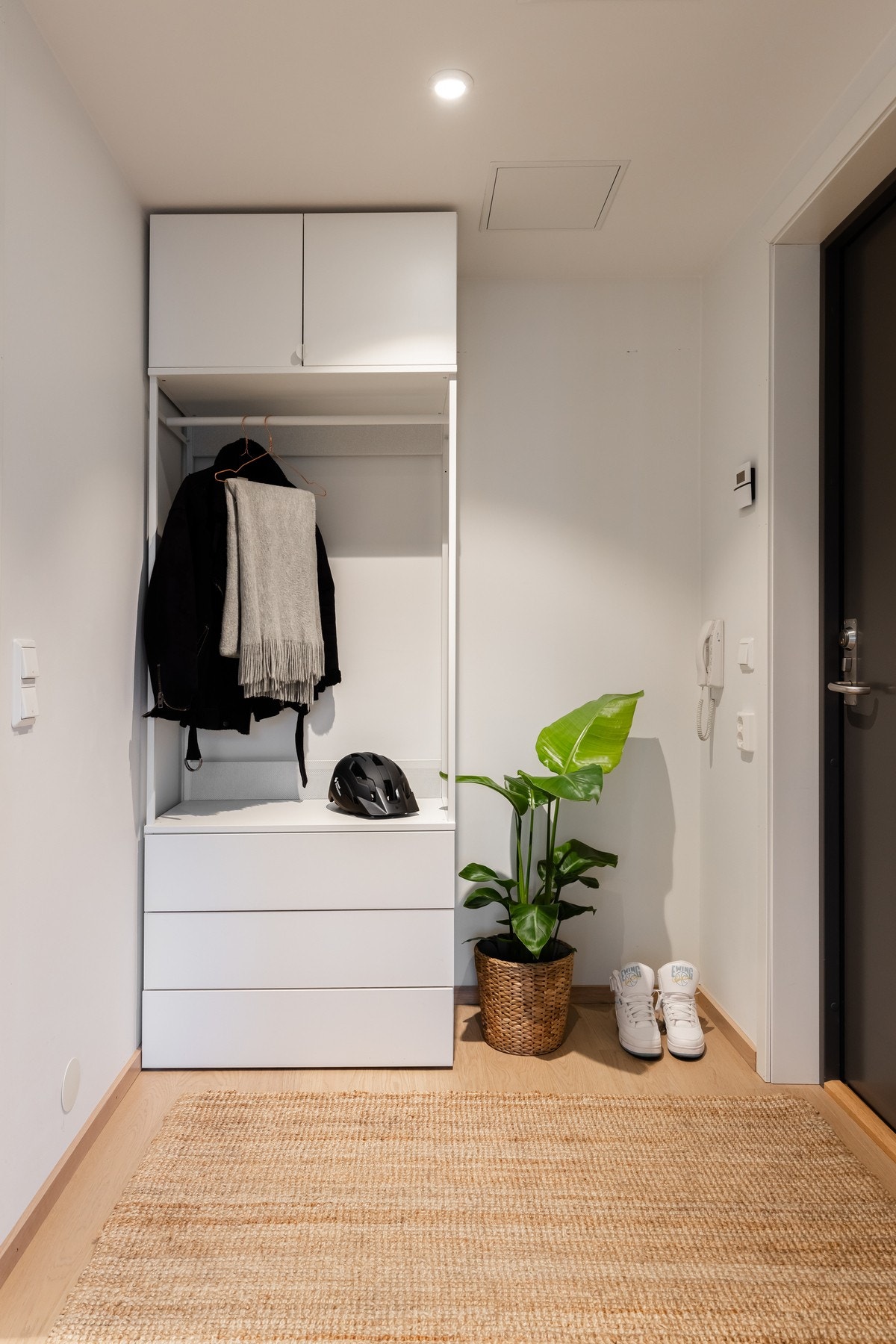 I entreen står en seksjon med skuffer, skap og garderobestang for oppbevaring av klær og sko. Galleribilde