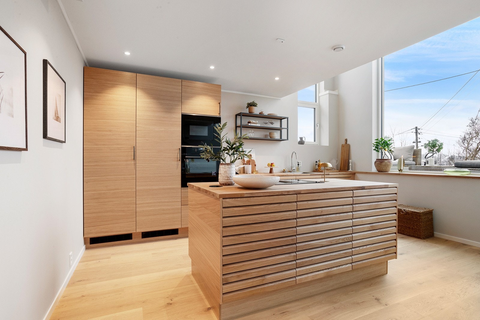 Innbydende kjøkkenløsning med kjøkkenøy hvor koketoppen er plassert. Galleribilde