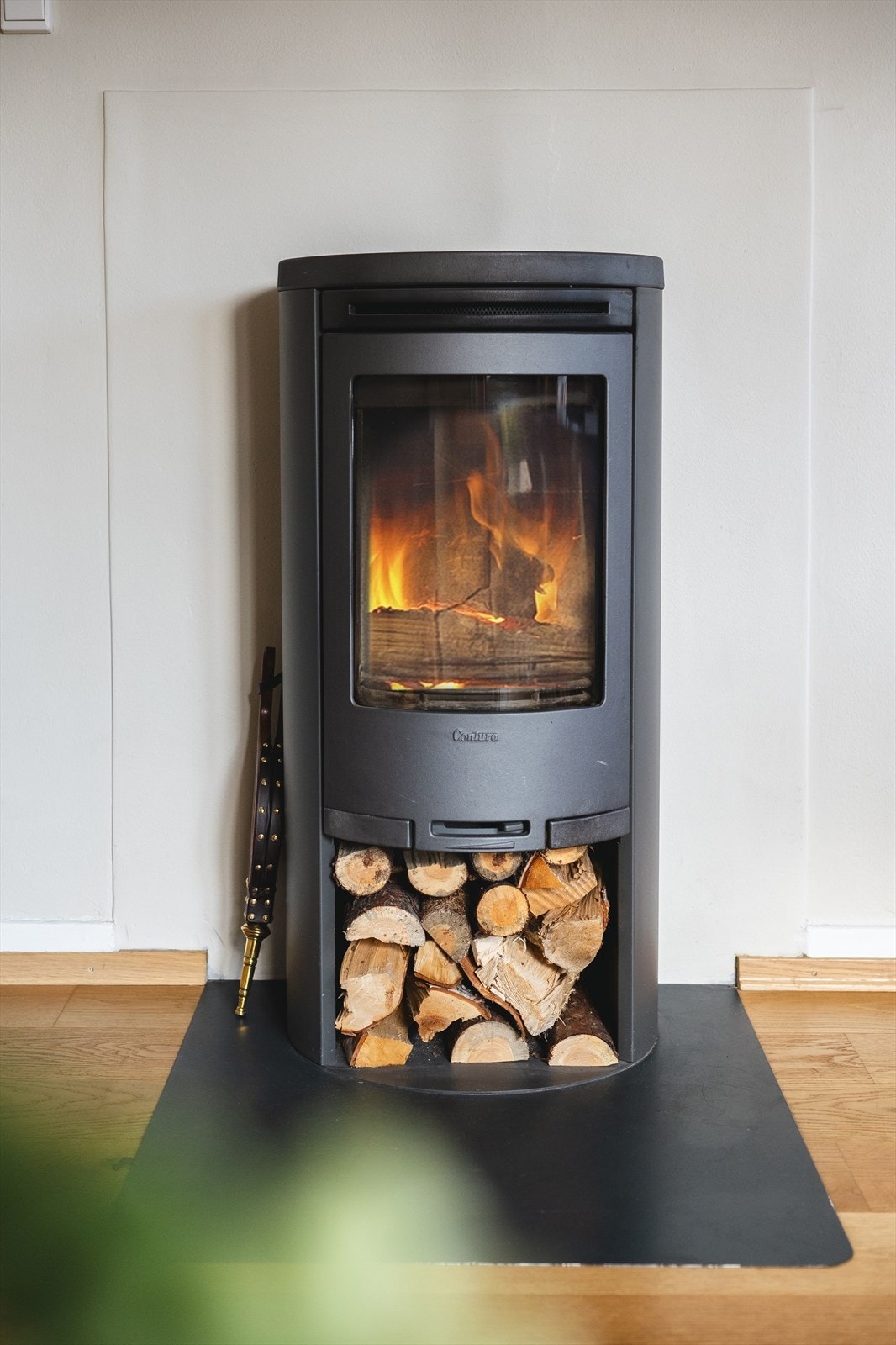 Midt i rommet står en stilren vedovn som gir ekstra varme og en lun atmosfære. Galleribilde