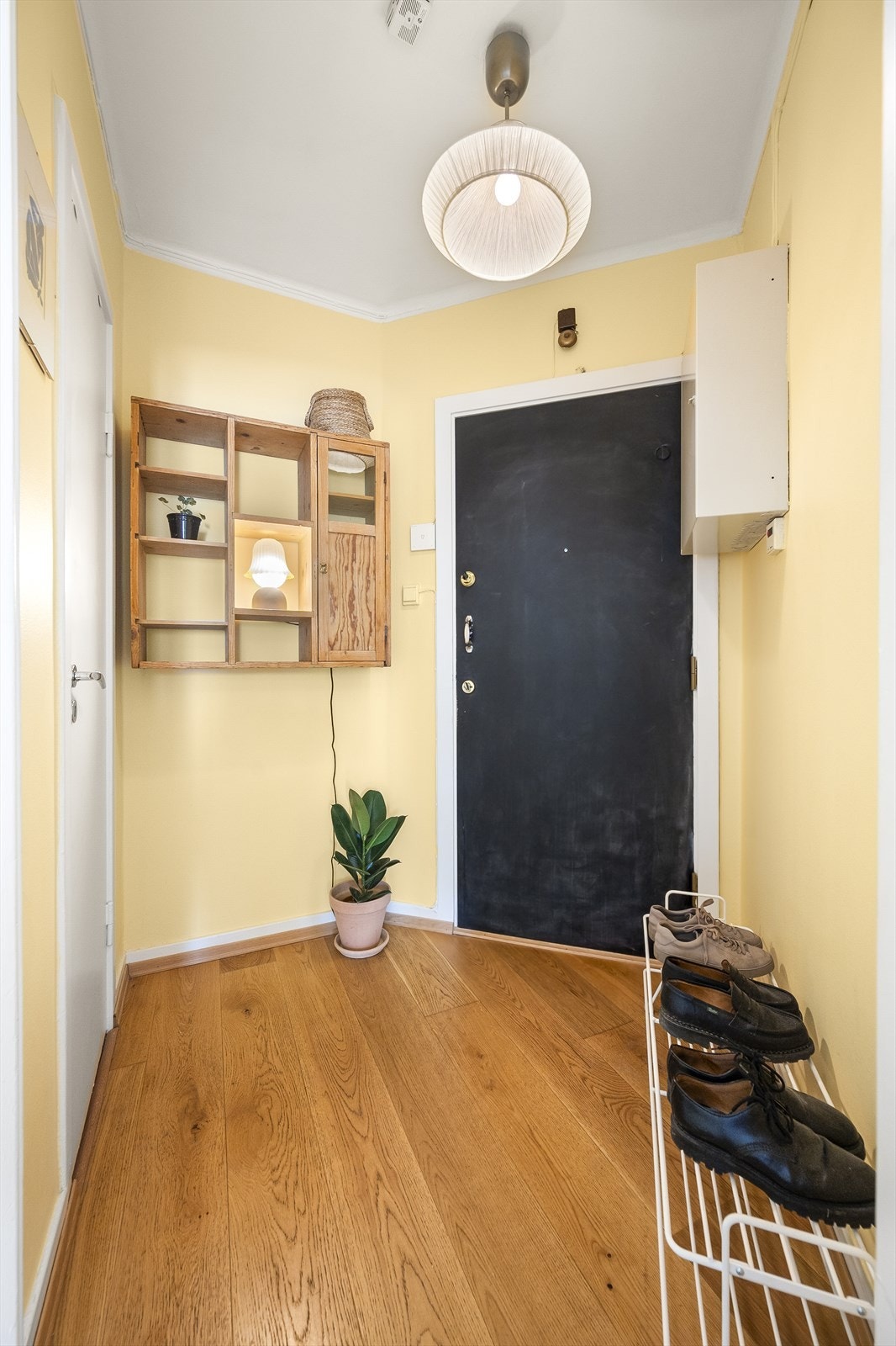 Lys og innbydende entré med varme gule vegger og flott gulv. En funksjonell gang med plass til oppbevaring og en hyggelig atmosfære. Galleribilde