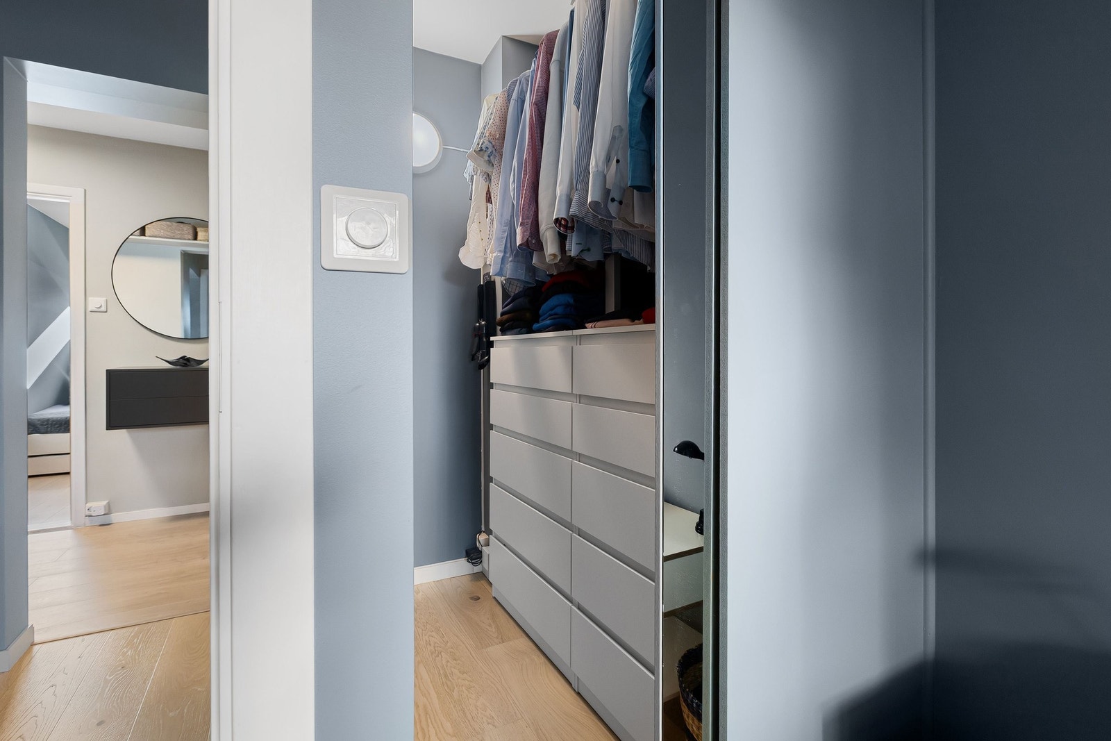 Walk-in-closet med plass til masse klær på kleshengere og i skuffer. Galleribilde