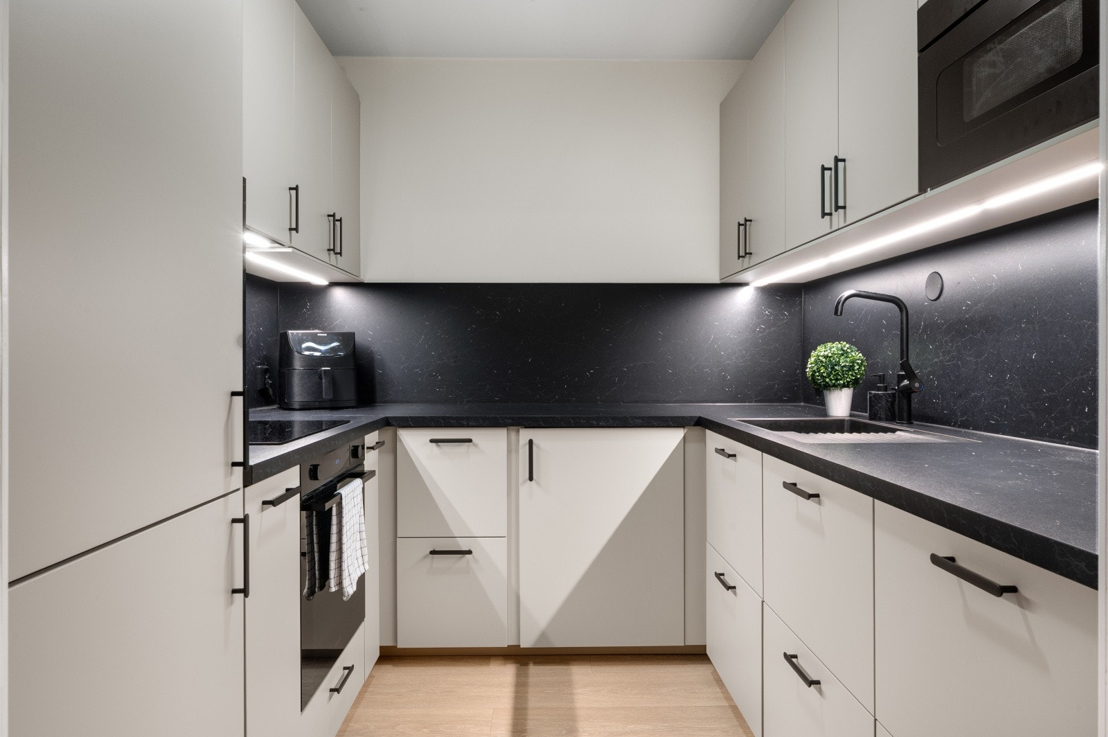 Lekker kjøkken fra 2024 med slette fronter, laminert benkeplate, plater mellom benkeplaten og overskap og selvsagt integrerte hvitevarer. Galleribilde