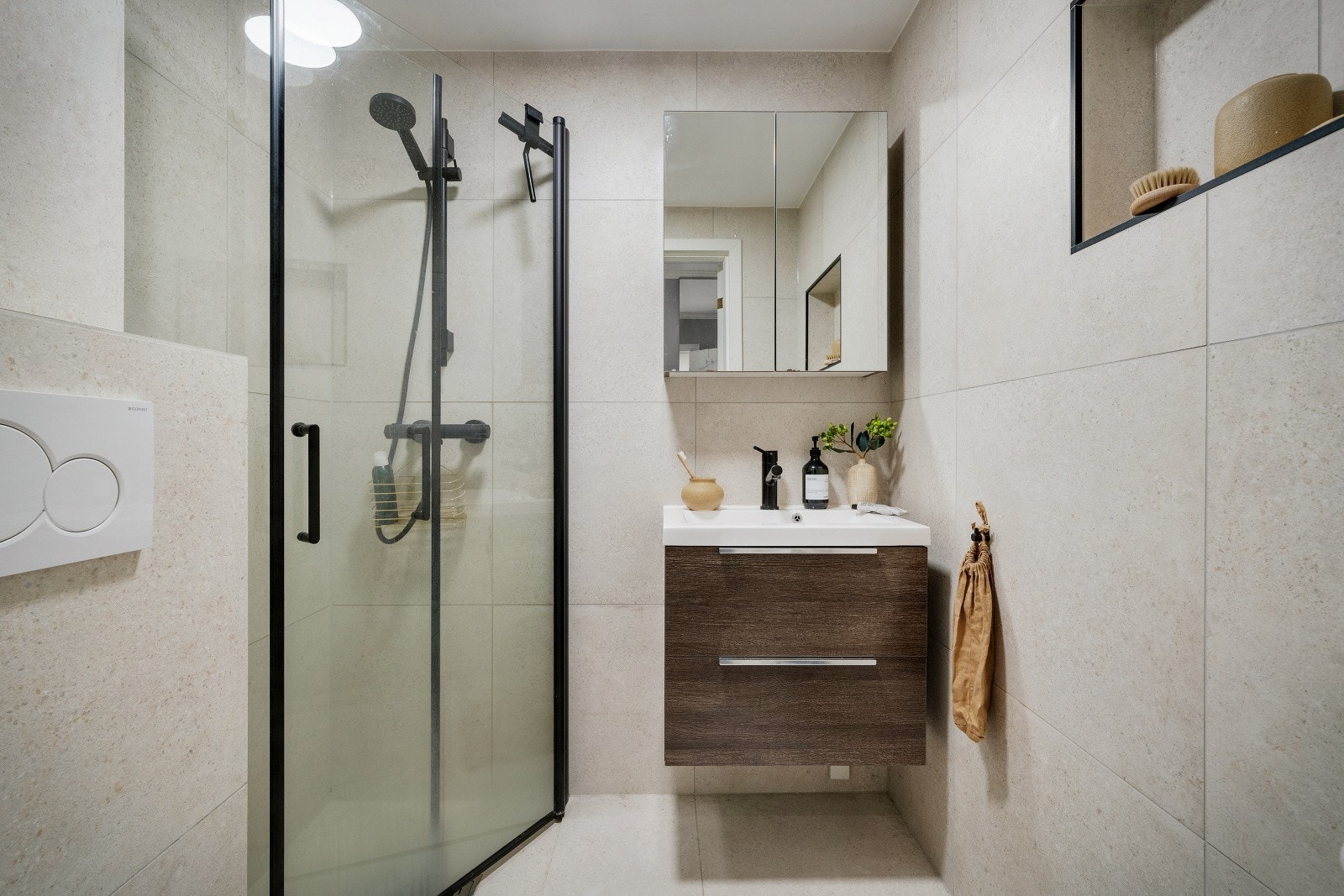 Badet er innredet med servant med oppbevaringsplass i skuffer, vegghengt WC og hjørnedusj Galleribilde