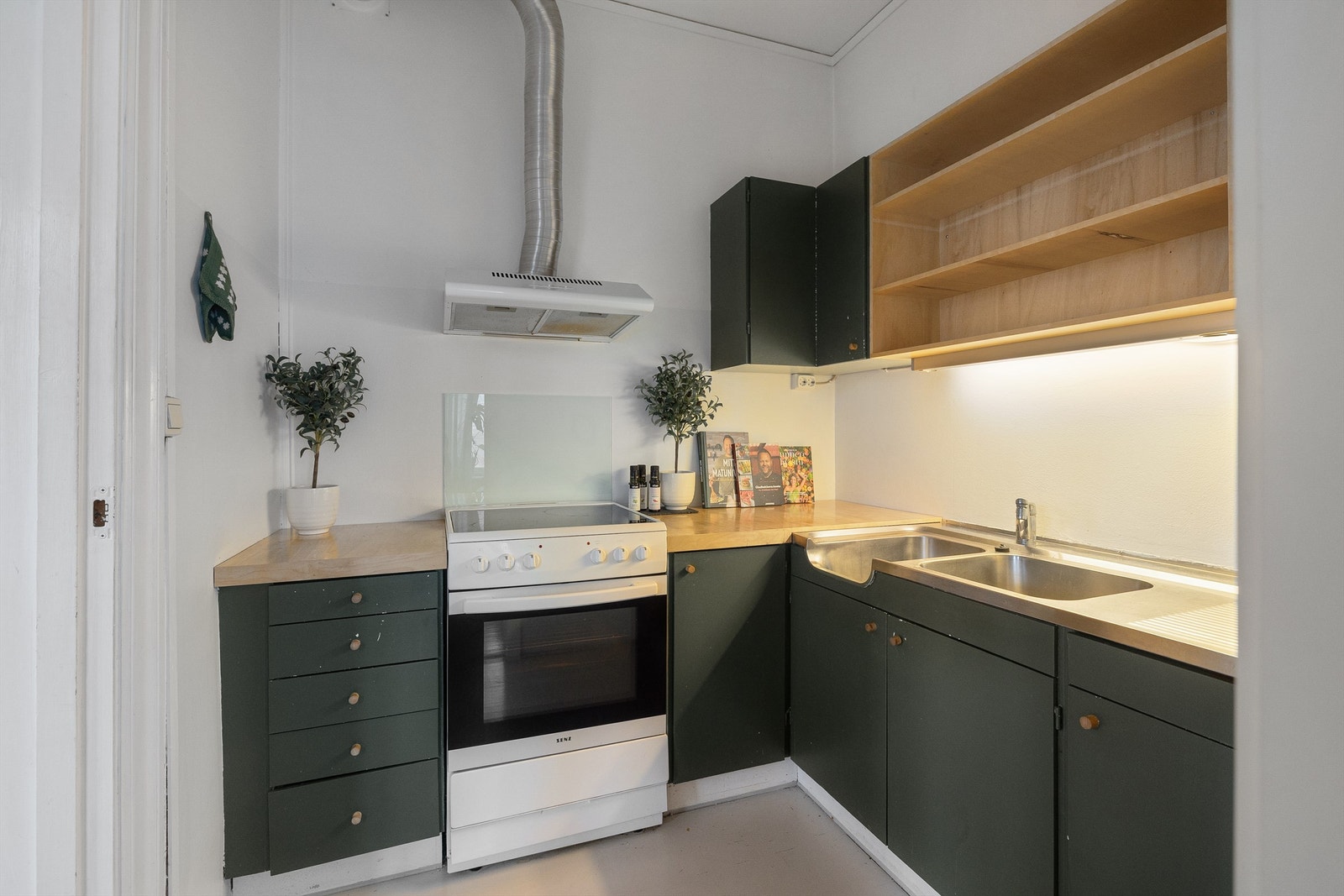 Kjøkkeninnredning fra ukjent årstall med glatte fronter, og benkeplater av laminat med nedsenket oppvaskkum med ett-greps armatur. Galleribilde