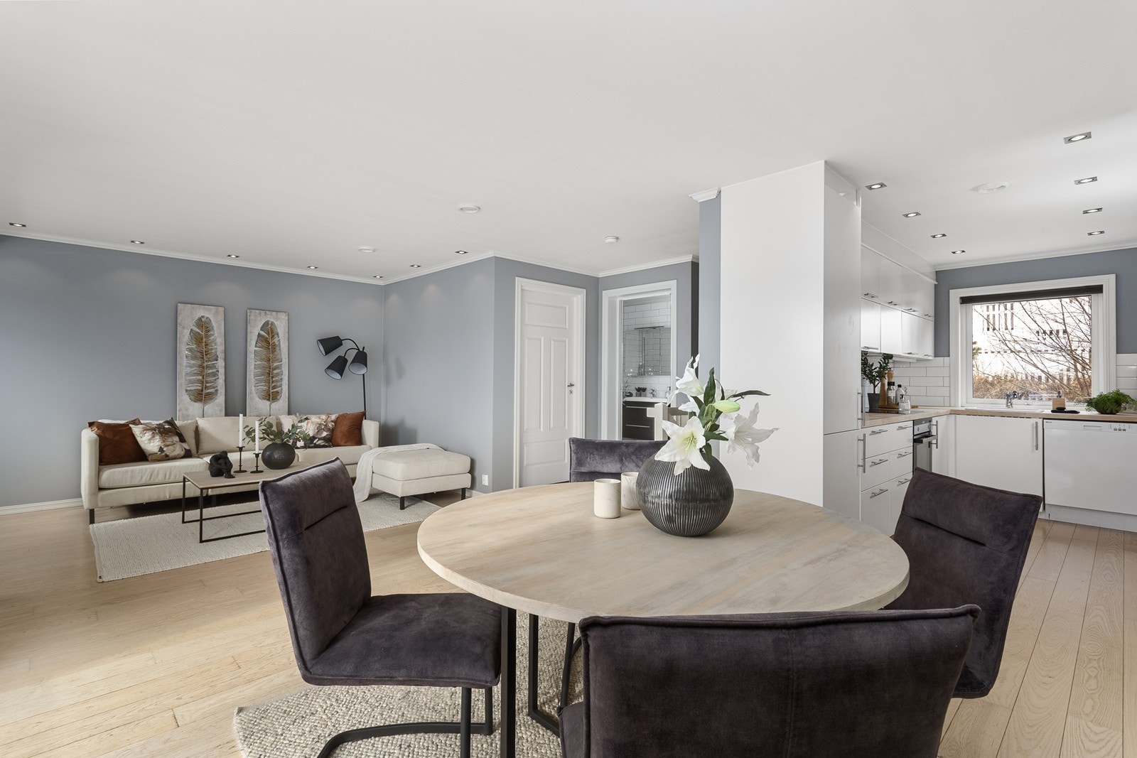 Stuen har lyse overflater med malte vegger, parkett på gulv og downlights i tak Galleribilde