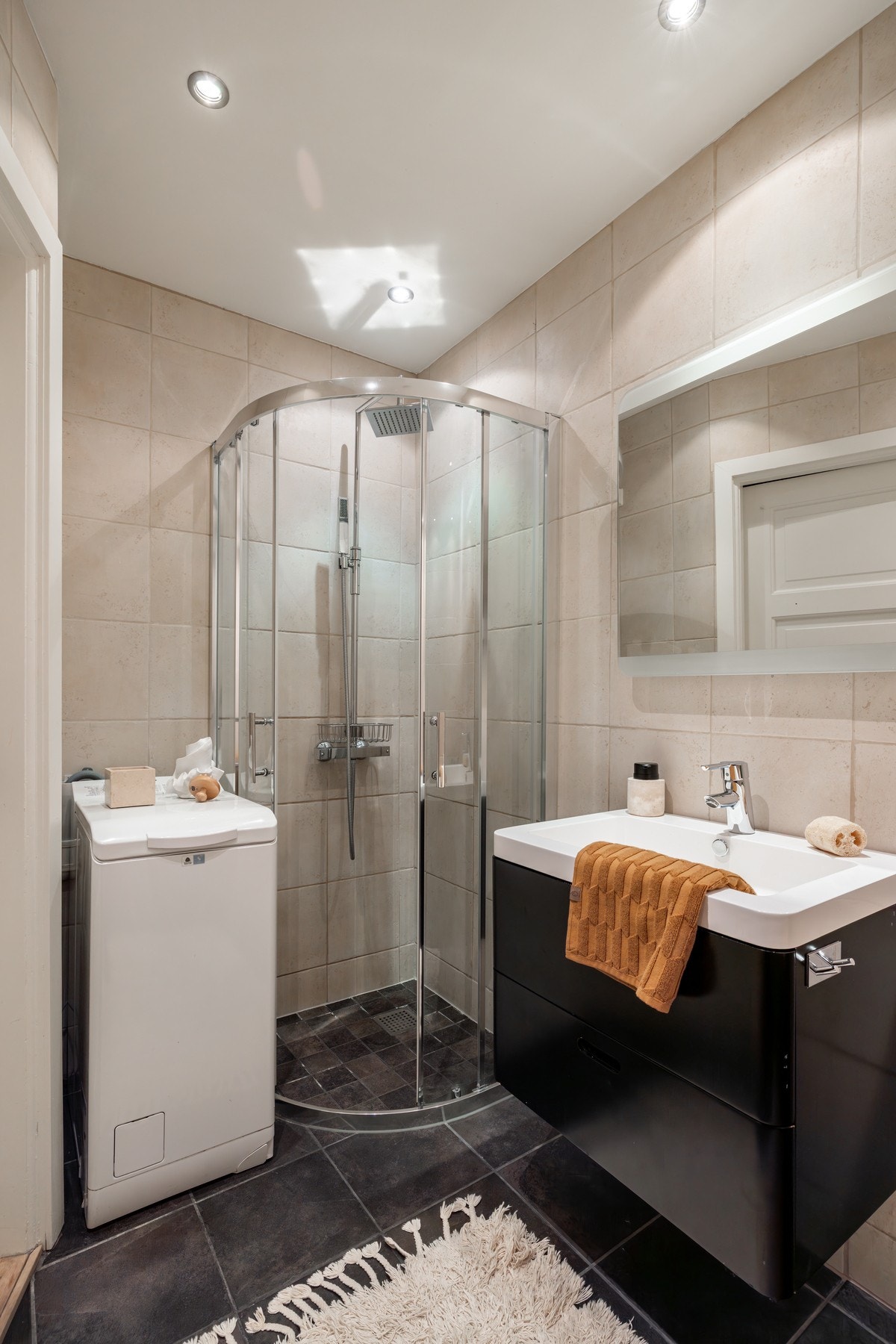 Badet er utstyrt med en moderne servantinnredning, toalett og dusjsone. I tillegg er det opplegg for vaskemaskin. Galleribilde