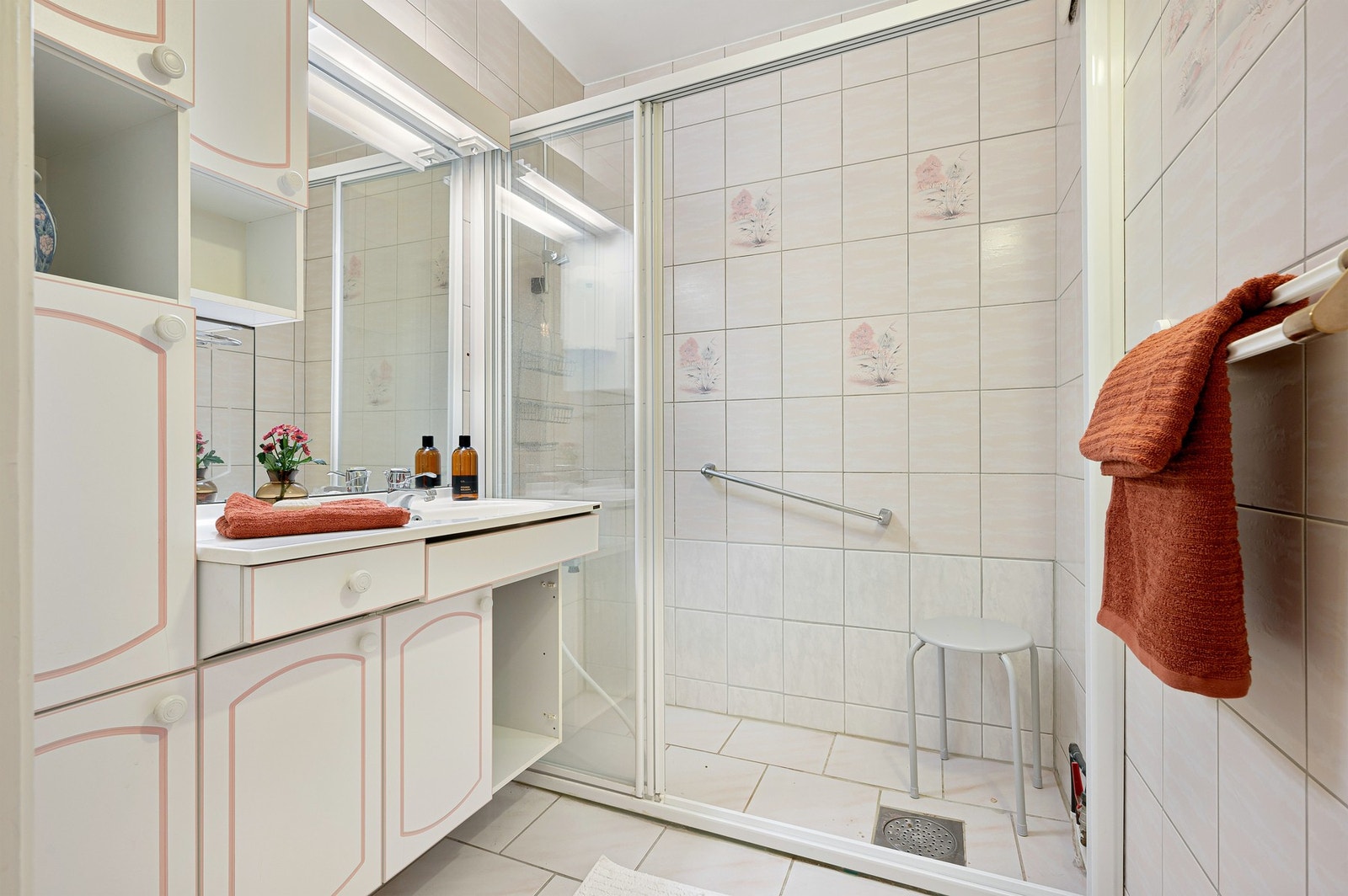 Lyst baderom som har flis på gulv og vegger. Galleribilde