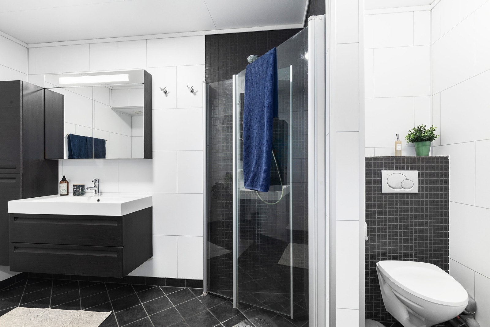 Badet er av god størrelse. Det inneholder stilren innredning med skaplass, dusjsone med innfellbare glassvegger, opplegg for vaskemaskin og vegghengt toalett. Galleribilde