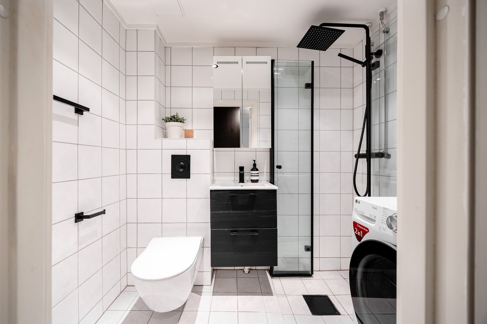 Stilrent bad med varmekabler i gulv og opplegg for vaskemaskin. Galleribilde