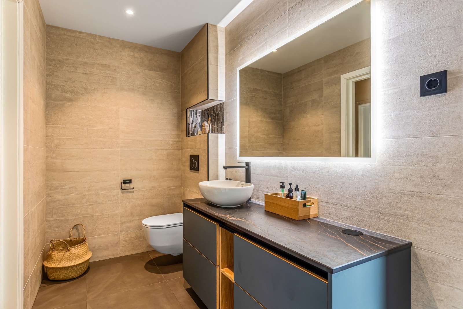 Badet er av god størresle og er bestående av servant med underskuffer, badekar, dusjhjørne og vegghengt toalett Galleribilde