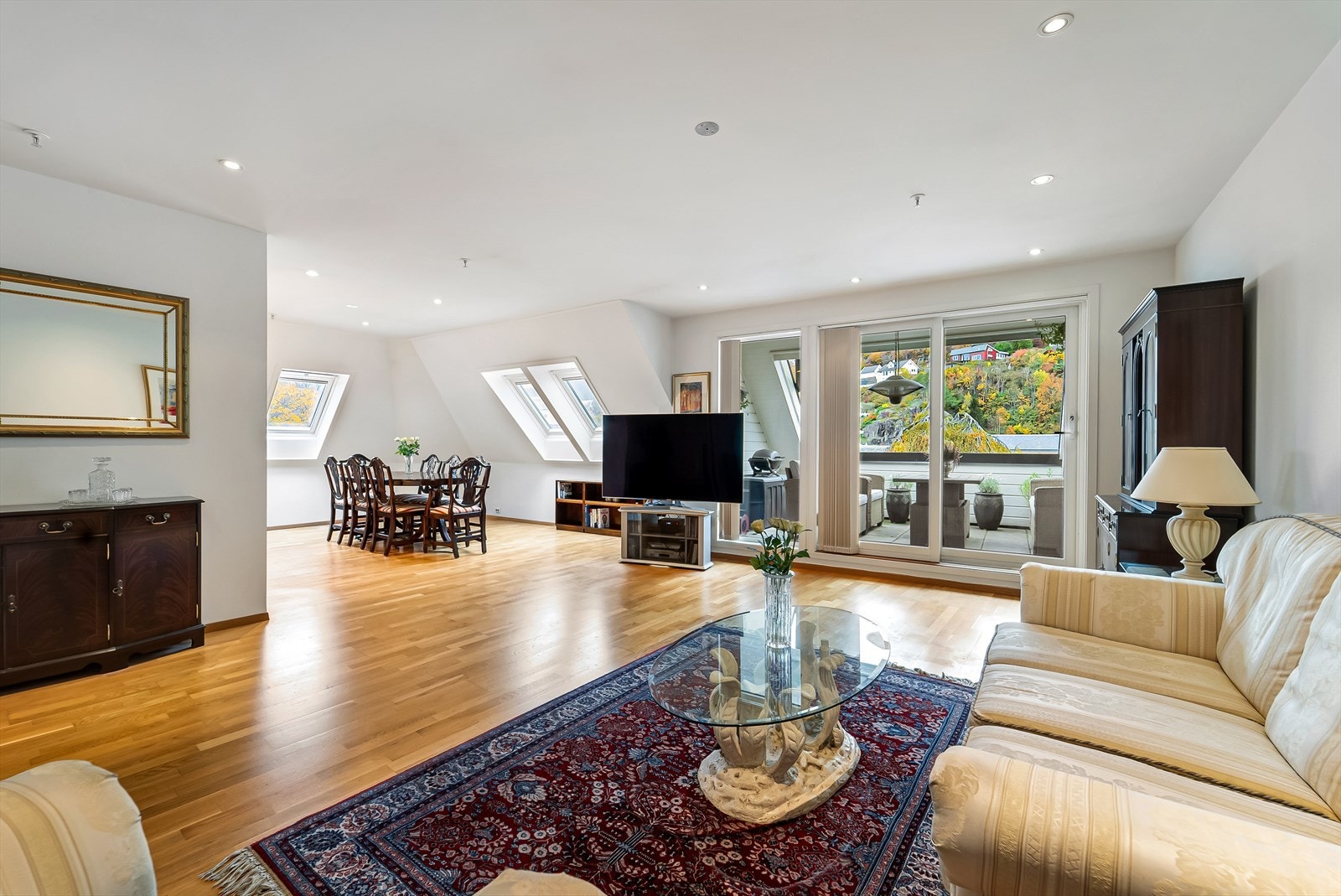 Lys og romslig stue med slette vegger og tak med downlights. Galleribilde