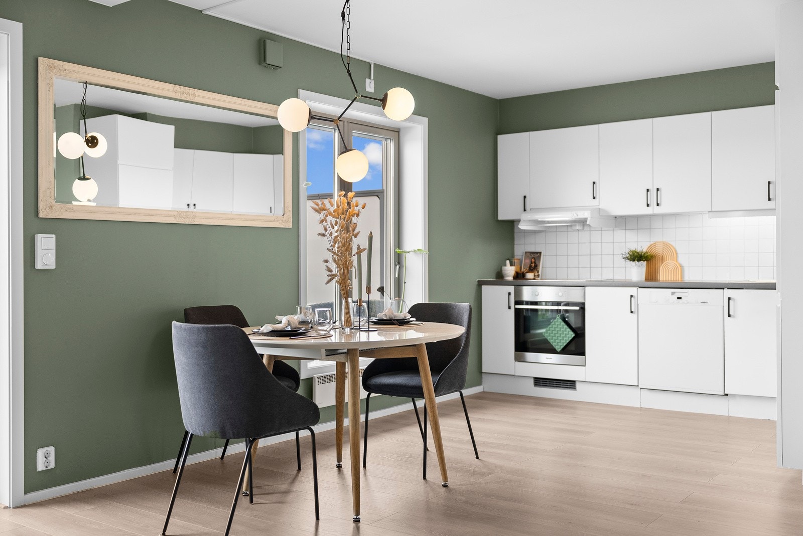 Det stilrene kjøkkenet er både funksjonelt og elegant, med hvite, slette fronter og en slitesterk laminatbenkeplate med nedfelt stålvask. Galleribilde