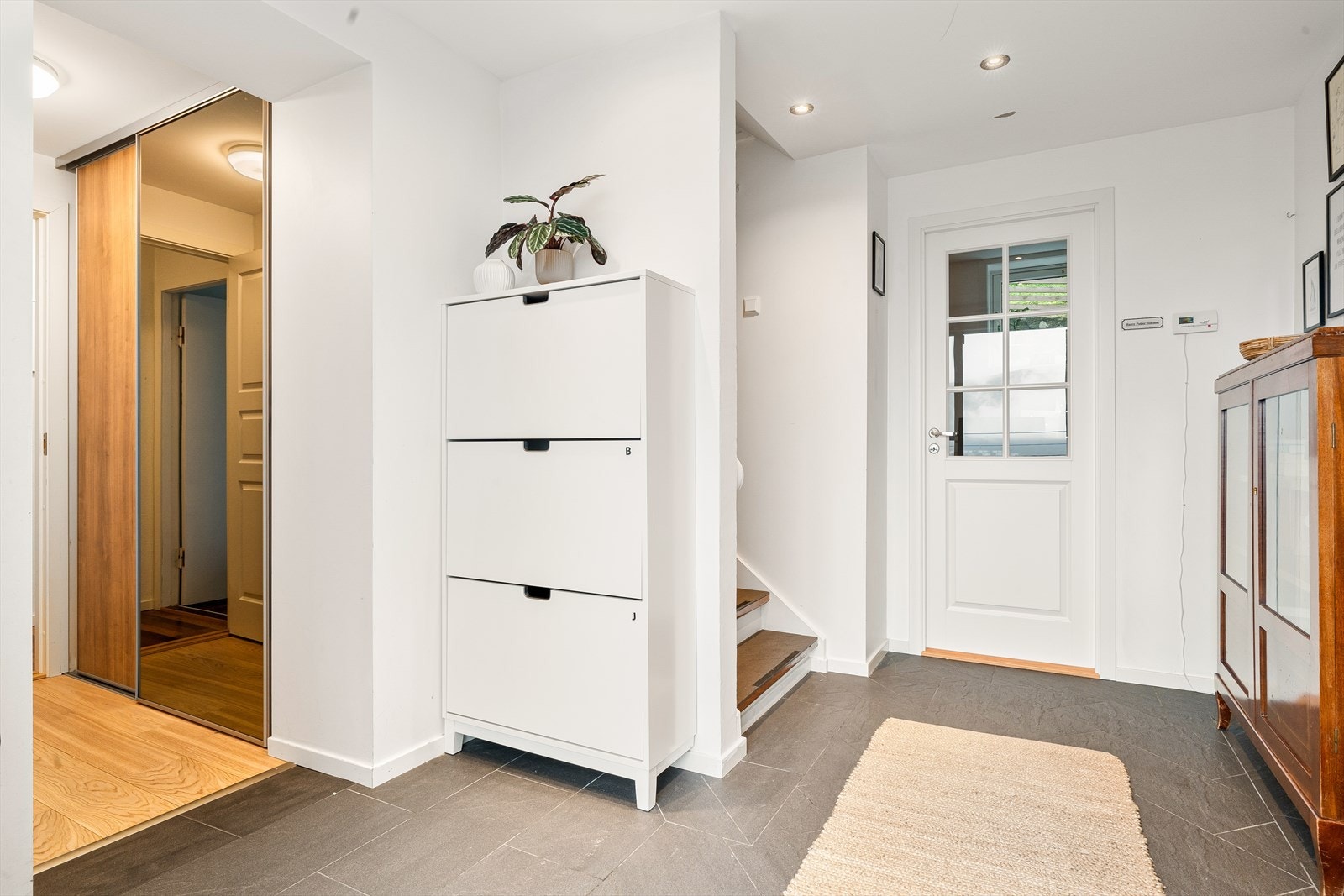 Entréen i underetasjen har flislagt gulv med varmekabler og kan møbleres med ulike oppbevaringsløsninger for yttertøy og sko. Galleribilde