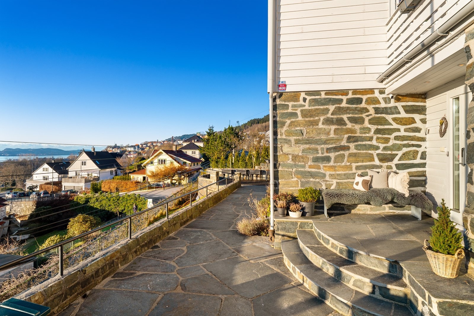 Klassisk smijernsrekkverk og flotte natursteinsmurer omkranser boligen. Galleribilde