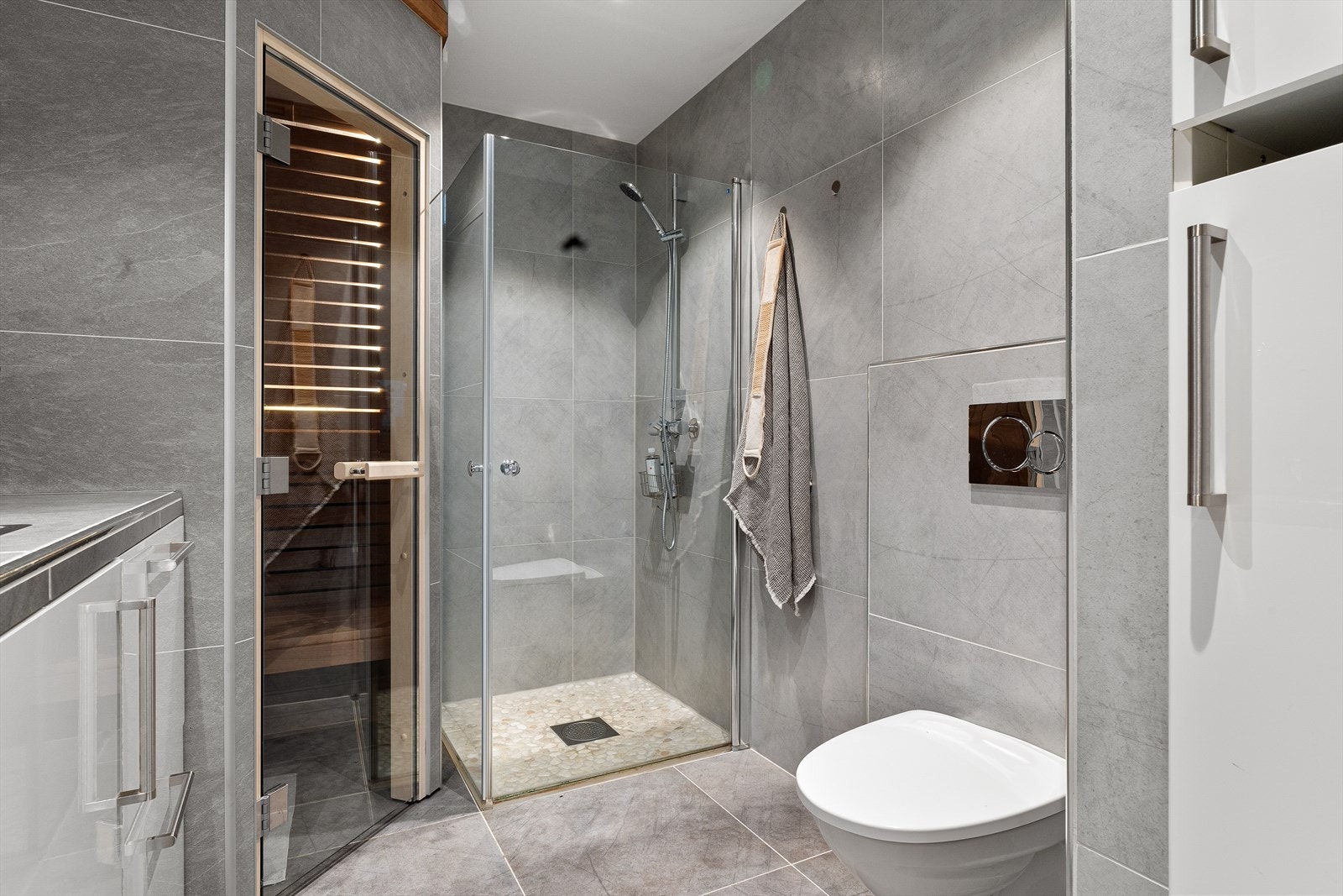 Badet har en moderne utførelse med flislagte overflater og innfelte downlights i himlingen. Galleribilde