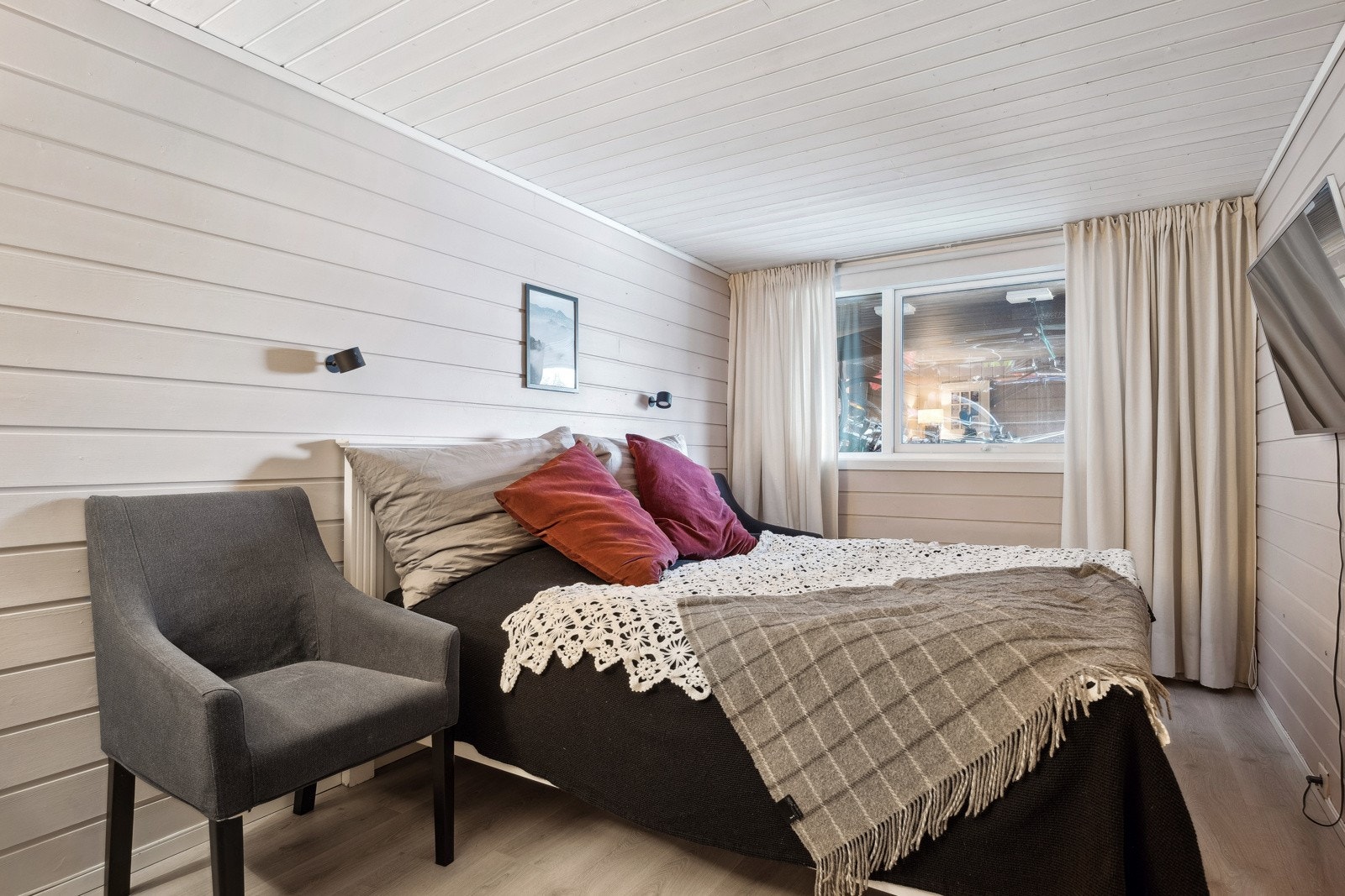 De lyse treveggene og varme tekstilene skaper en koselig atmosfære. Rommet er stort og har flere bruksområder, feks. som kjellerstue. Galleribilde